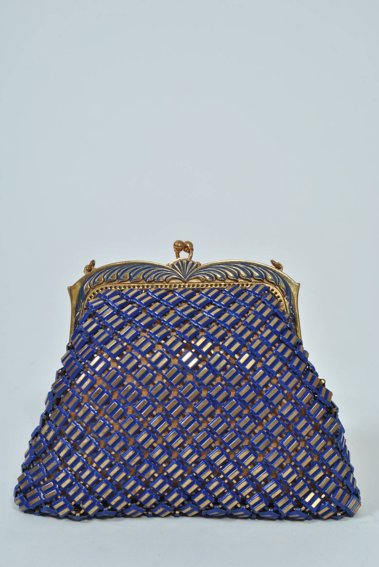 This is an unusual version of the iconic Whiting & Davis mesh bag composed of double-bar links in gold outlined with vibrant blue enamel, which also accents the scrolled gold frame. Kiss lock, beige taffeta lining, all in excellent condition. Narrow