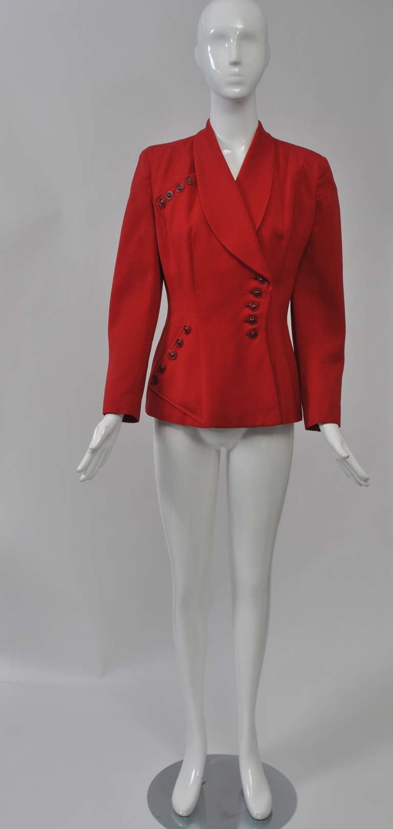 Red wool jacket from the late '40s/early '50s with interesting diagonal stitched and button detailing. Fitted, long jacket with shawl collar, padded shoulders, and bound buttonholes. Lined. Size M.