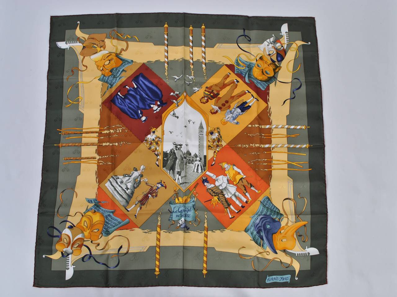 A beautiful example of why Hermes scarves are valued for their beauty and design, this one is rendered in shades of dark green against warmer tones. The composition is an interplay of geometry and figural delights from the Commedia dell'Arte,