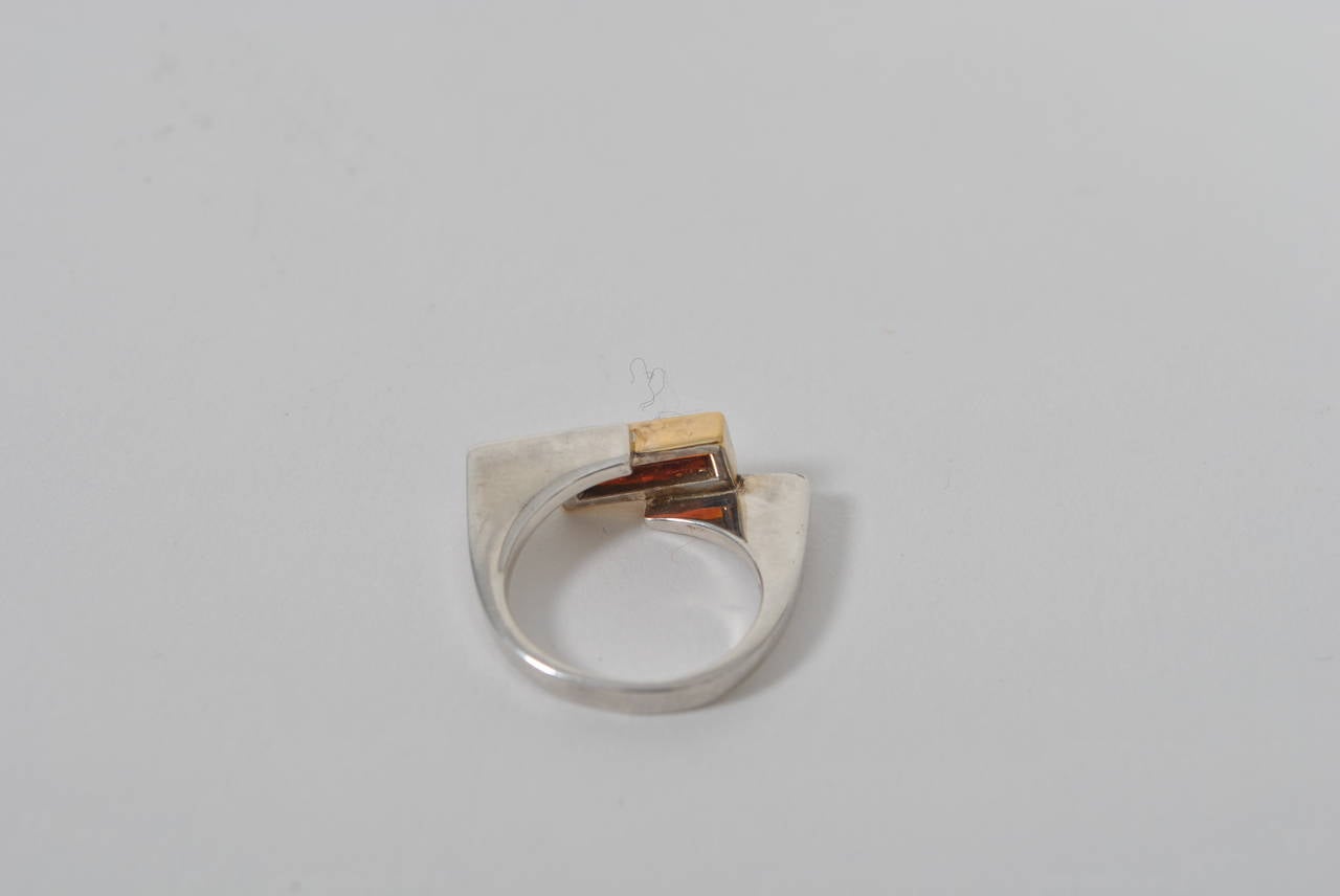 Modernist sterling ring with angular, asymmetric setting. Center rectangle with gold wash set with orange-colored gemstone.