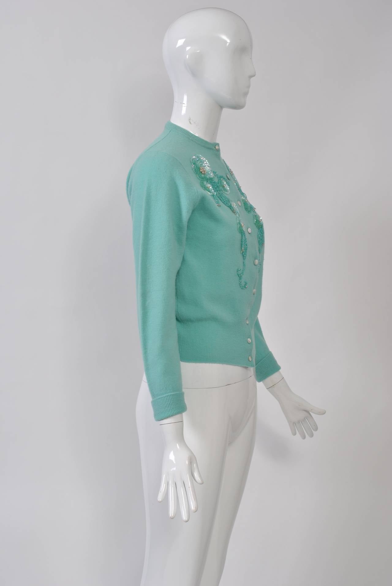 Among our favorite vintage pieces are the decorated cardigans from the 1950s-'60s. This example is in a beautiful shade of aqua and is embellished with matching beads and sequins. Unlined. Small size.