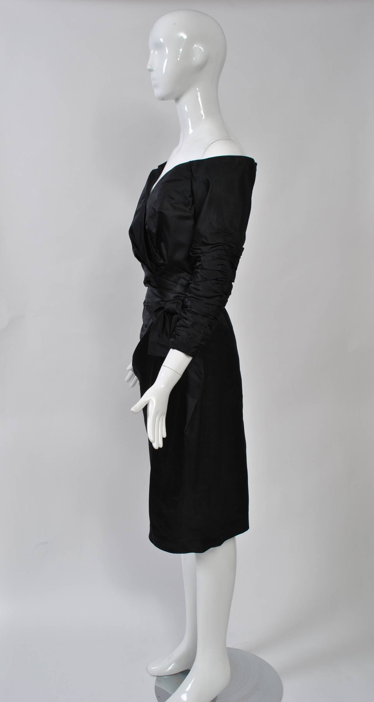 A great LBD from Victor Costa with a sweetheart necklace and stand-away shoulders. Fashioned of a black satin blend of silk and rayon, the dress features shirred details on the bracelet-length sleeves and through the surplice bodice, which is held