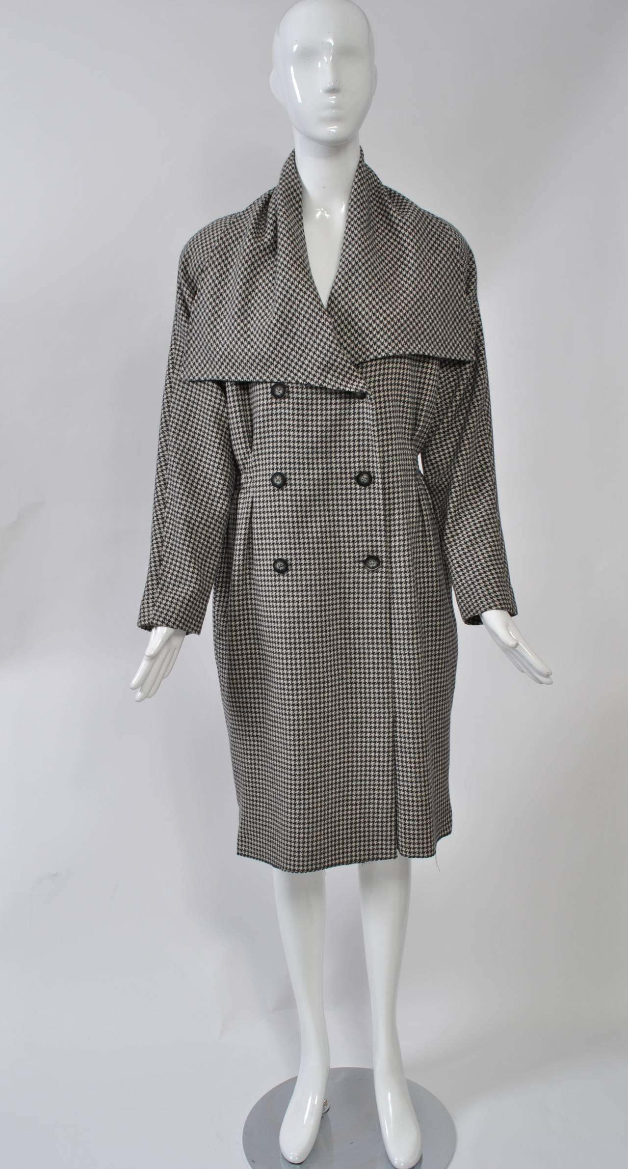 Tiktiner, cappotto oversize a quadri grigi, doppiopetto, con vita stretta, ampio colletto e maniche raglan. Il tessuto è morbido al tatto. Sembra perfetto con la cintura.