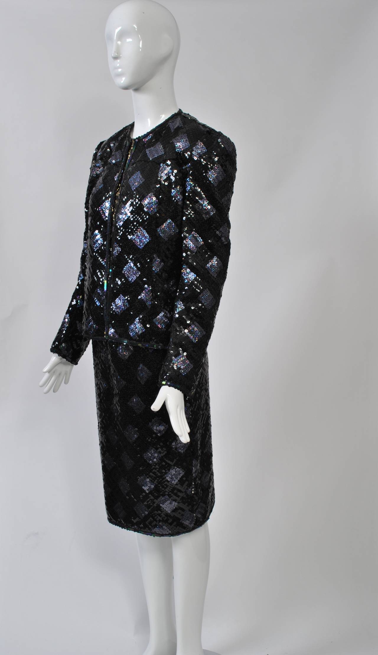 Three-piece evening suit by Adolfo, the slim skirt and collarless jacket in diamond-patterned black and iridescent sequins. The sleeveless shell is made of a krinkle metallic gold fabric, as is the lining of the jacket and the waistband of the