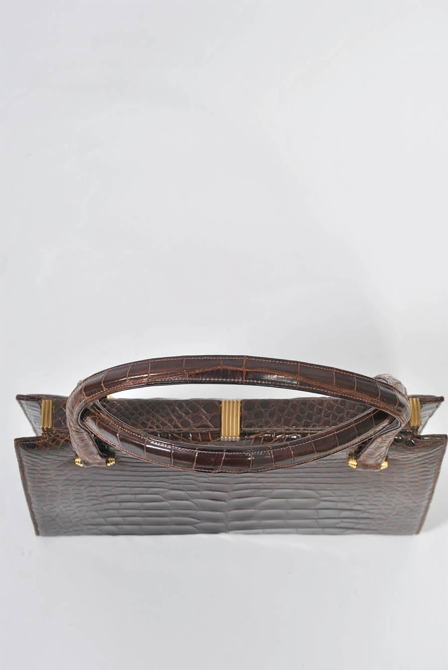 Classica e chic borsa in alligatore marrone degli anni '60 di Lucille de Paris. Pelli belle, simmetriche e lucenti, doppio manico, minuteria in metallo dorato. Interno in pelle marrone con scomparti multipli e portamonete. Splendide condizioni