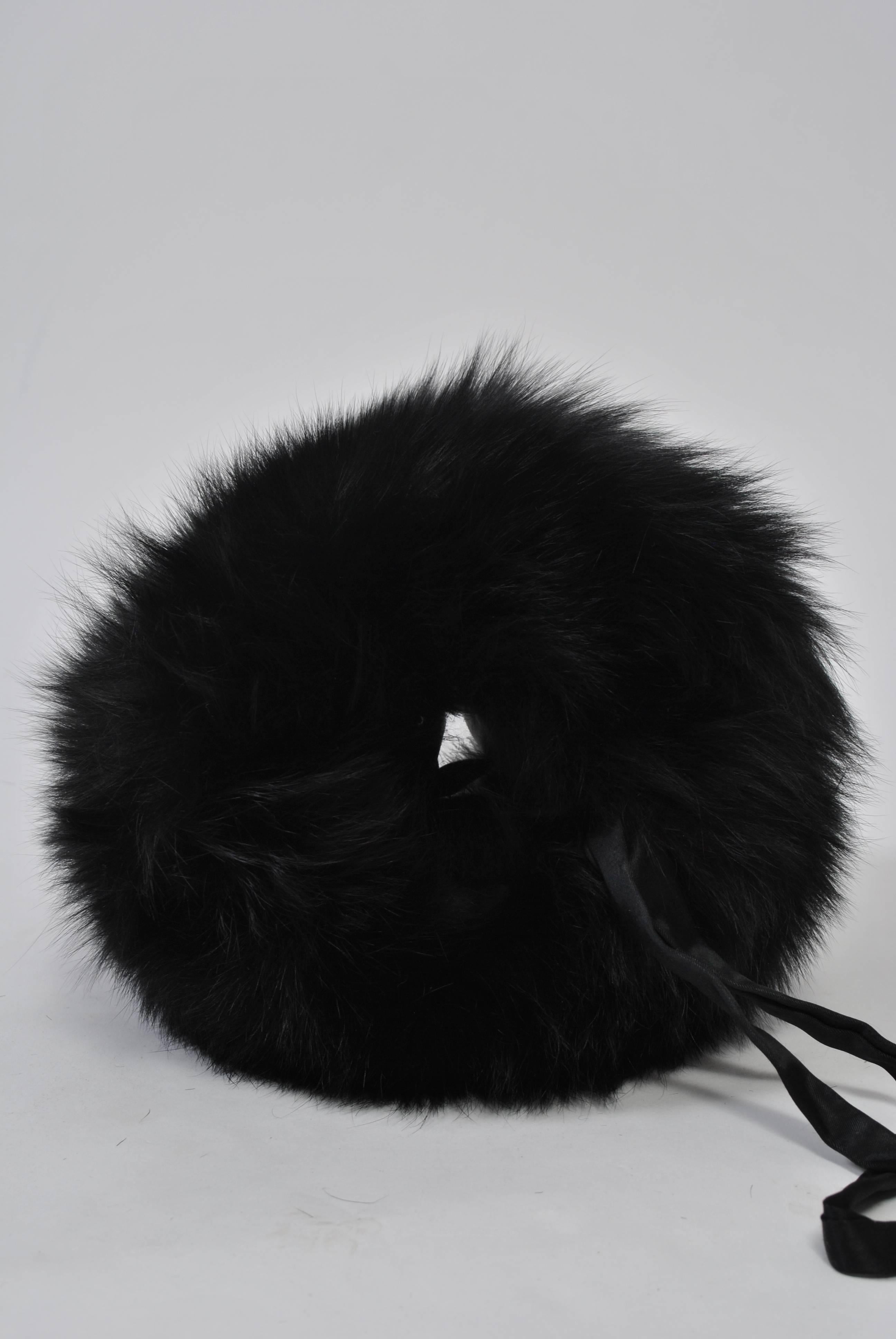 A big fluff of black fox defines this muff, cozy and warm with wrist strap and interior compartment. Skins in excellent condition.