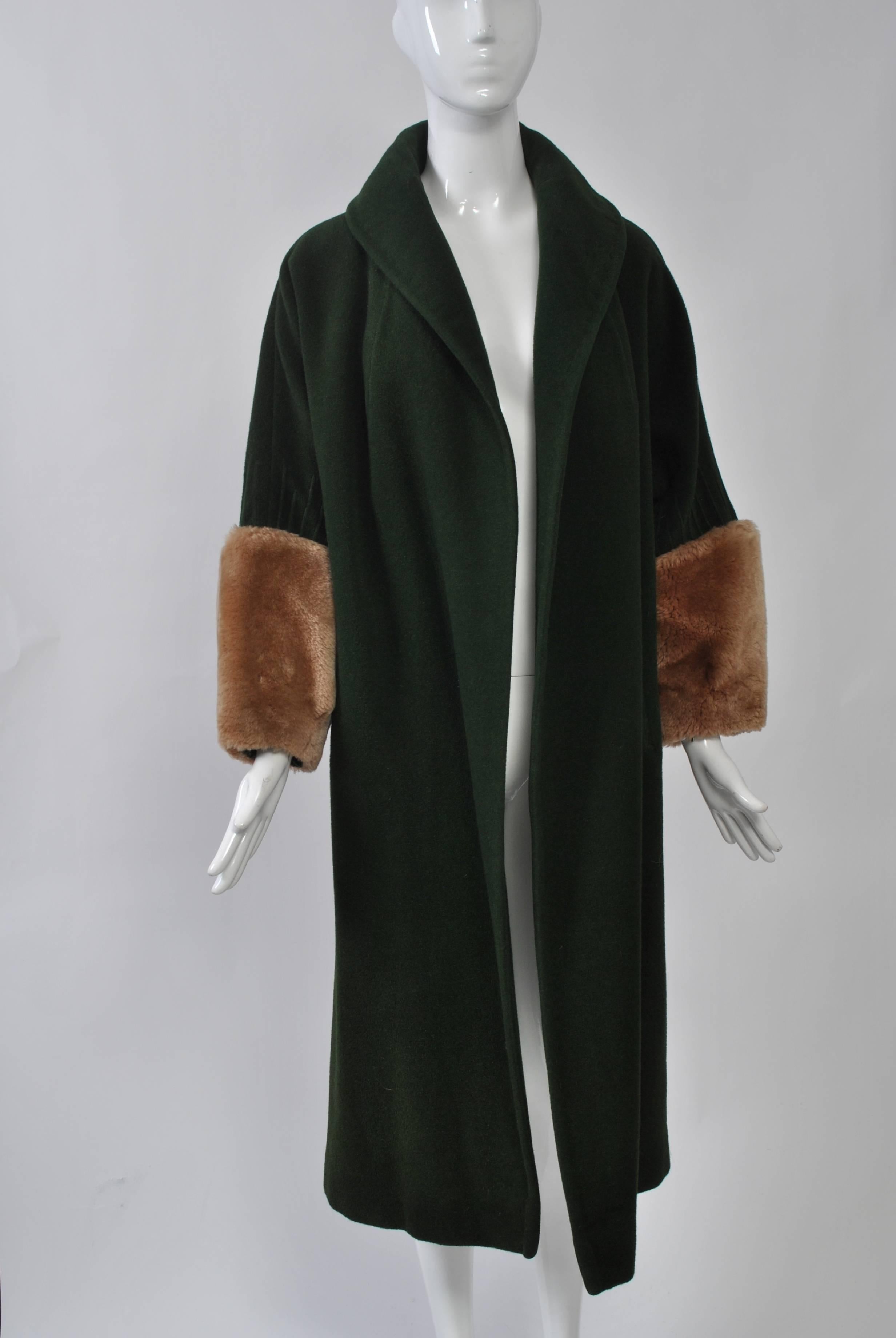 Lilli Ann clutch coat in forest green plush wool with deep fur cuffs, probably mouton. Straight, below-the-knee cut with shawl collar and vertical stitching on the sleeves above the cuffs. Size S-M.