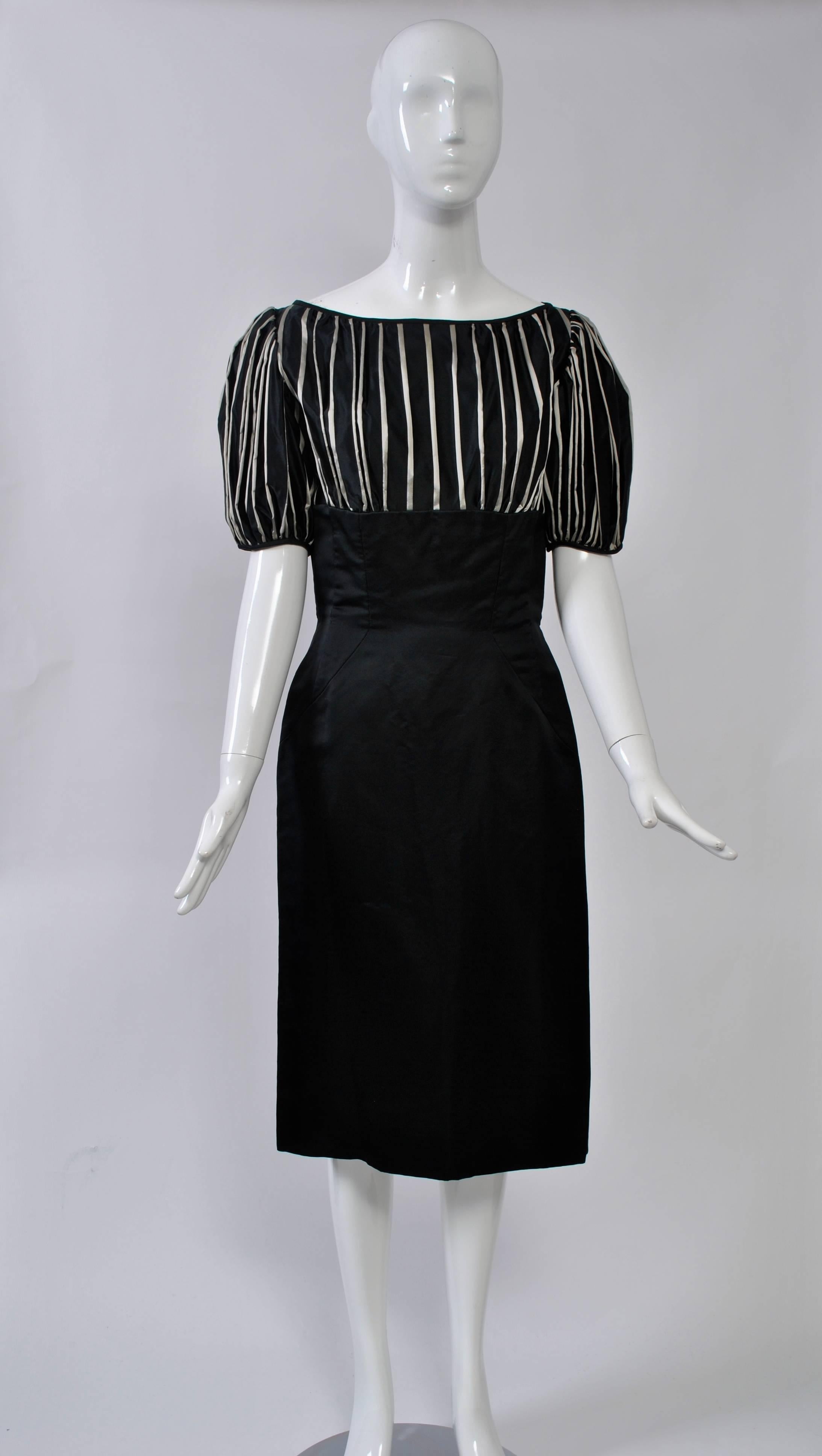 Estevez 1950s slim, fitted sheath has all the detailing in the empire bodice, which is fashioned of a black and silver stripe silk and features a wide neckline and puffed sleeves. The rest of the dress is in black silk faille. Back pleat. Lined.