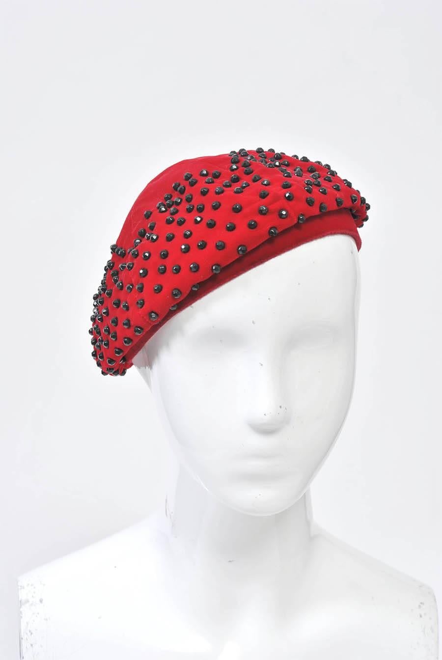 Red beret studded with faceted black jet beads arranged in a zigzag pattern toward the crown.