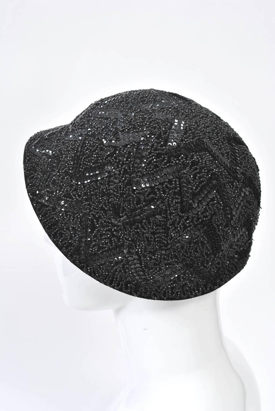 Cappello in feltro nero a tesa bassa ornato da perline e paillettes con motivi a zig-zag e a ghirigori.