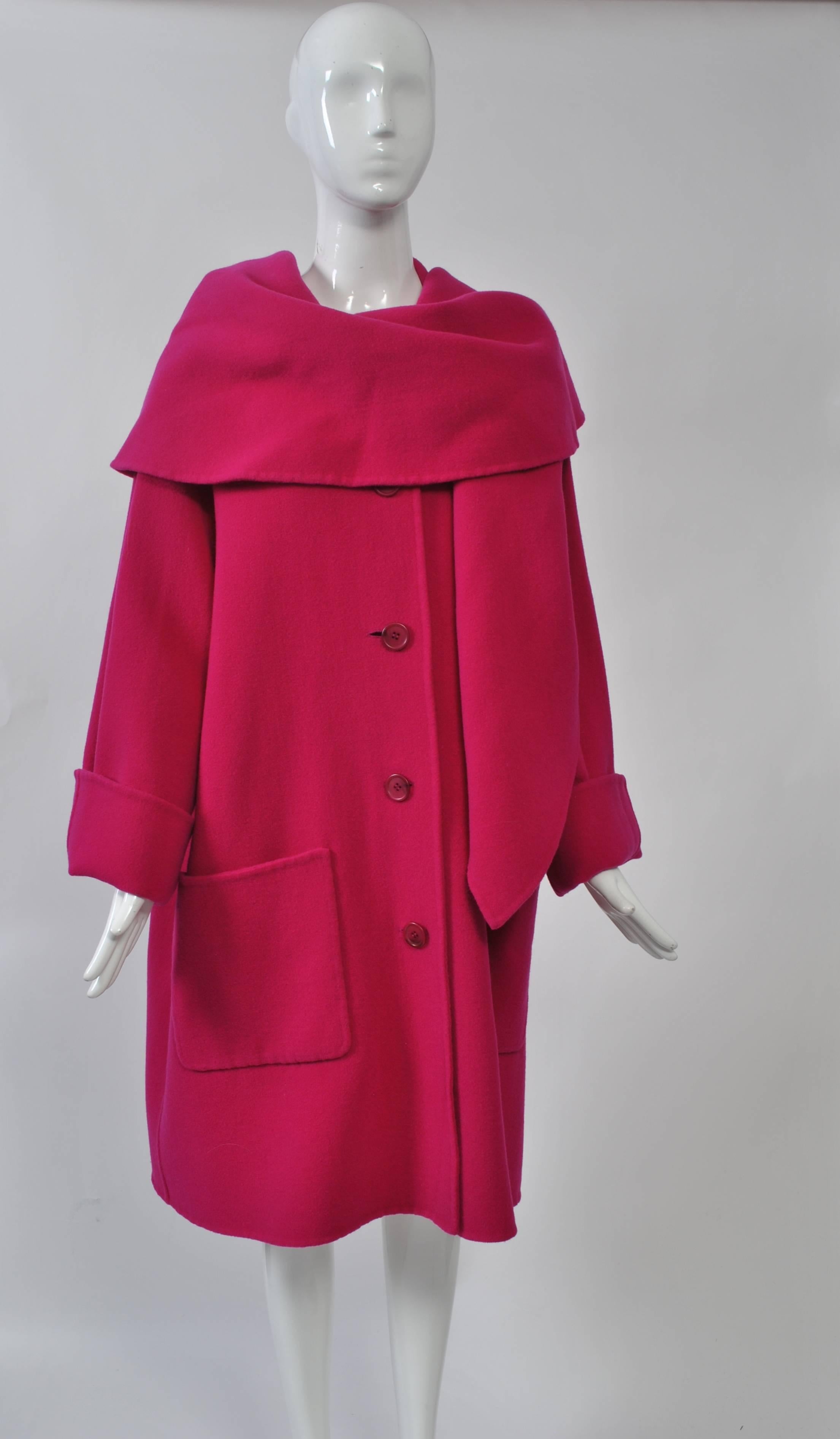 Double-faced fuchsia wool swing coat with deep shawl collar, single breasted with low patch pocket and turn-back cuffs. Welted seams. Unlabeled. Size M.