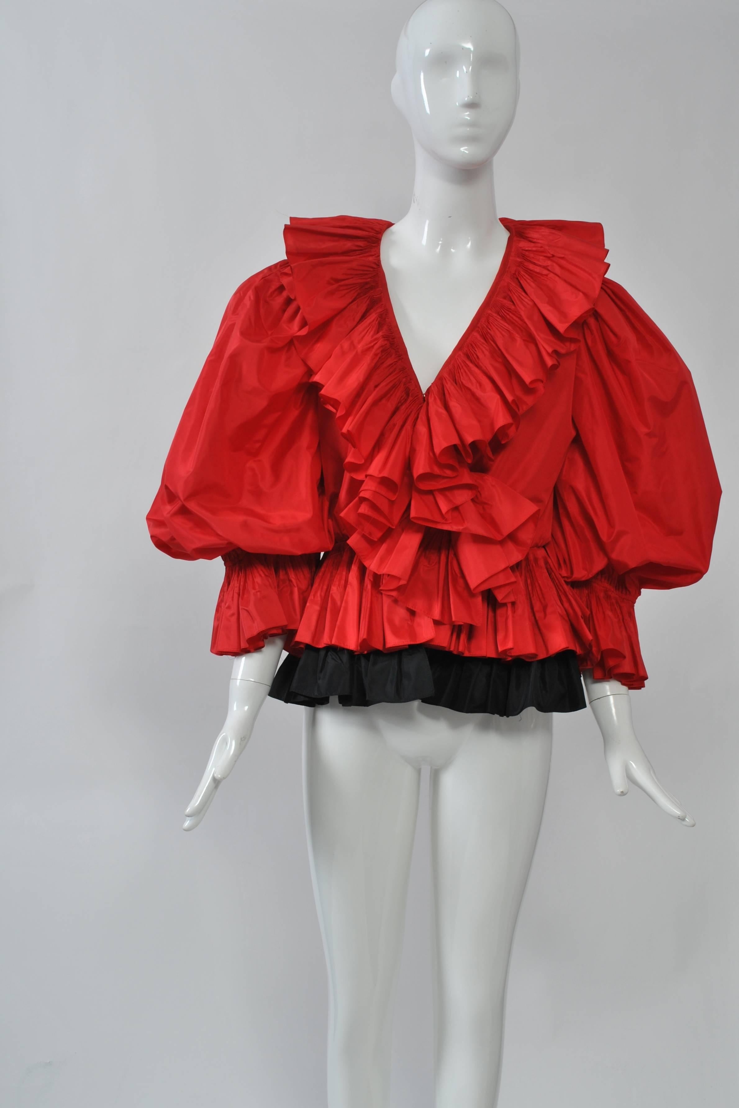 Extravagantly ruffled top in red silk taffeta with double-ruffle peplum, the underneath layer in black. Full, puffed sleeves with elastic ruffle cuffs. Unlabeled but surely a designer piece. Grosgrain tape at waist interior.