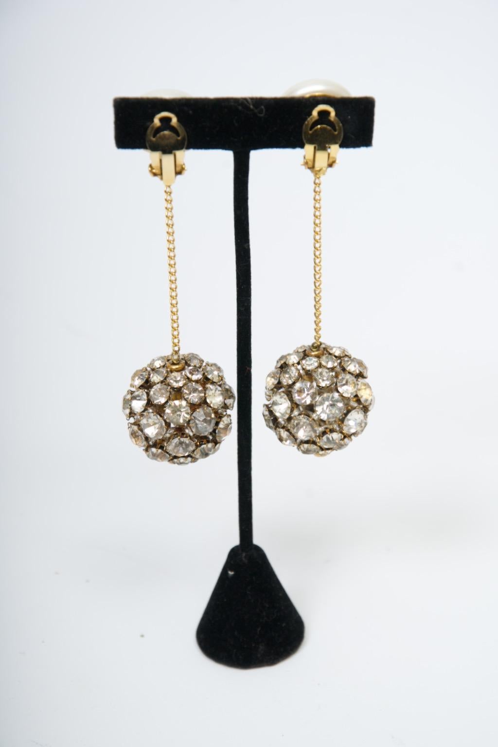 Sensazionali orecchini Chanel della collezione 28, 1992, composti da un orecchino di perle mabe con lunga catena dorata che sospende una grande palla da discoteca di cristalli incastonati. Una coppia rara che renderà speciale qualsiasi serata.