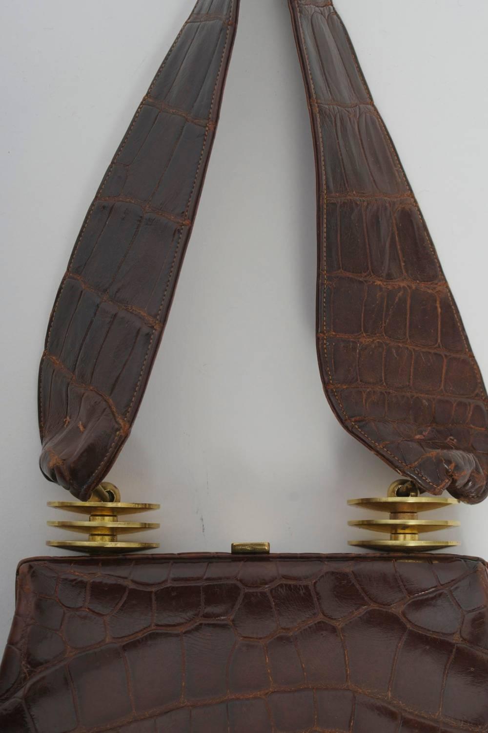 An early and rare example of one of the most respected American handbag designers, Harry Rosenfeld, whose firm created innovative and luxurious designs from the 1930s-1970s. Of brown alligator, this handbag has an unusual ovoid shape and features