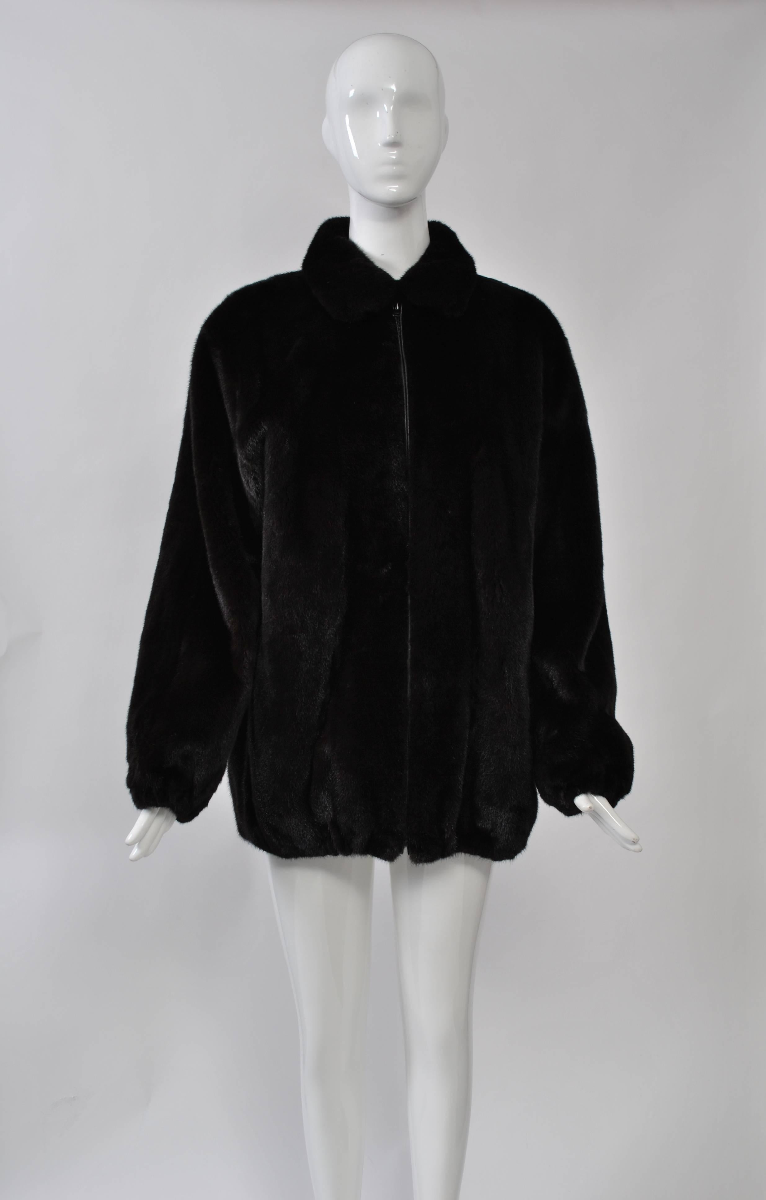 Plush Blackglama mink jacket in casual style featuring leather-trimmed front zipper and elastic hem and wrists. Supple, velvety skins, highest quality. Slit pockets. Size S-M.