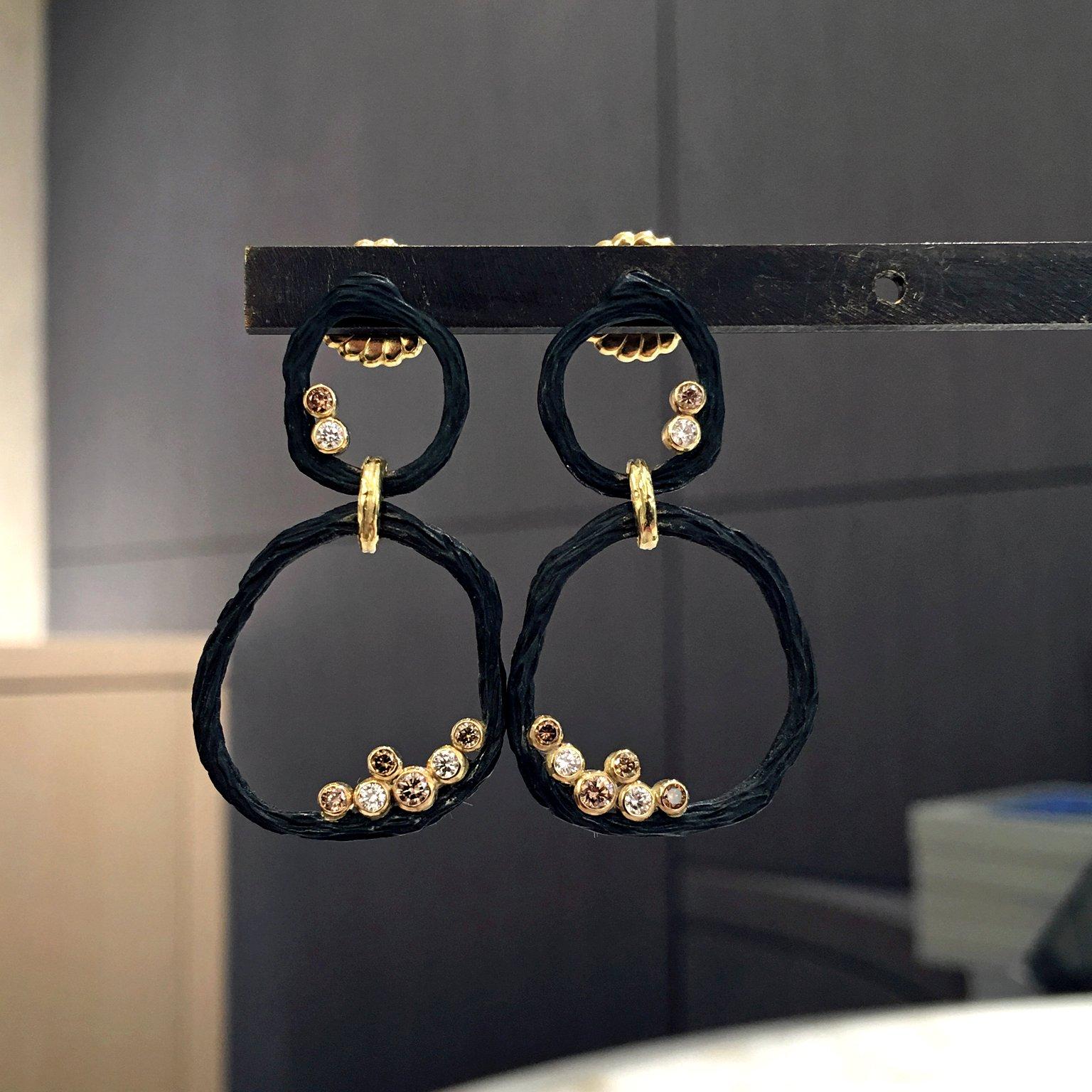 Double Circle Earrings handcrafted in pebble-finished black steel with 0.34 total carats of assorted size white and cognac round brilliant-cut diamonds bezel set in 18k yellow gold with 18k yellow gold pebble-finished links, and 18k posts and backs.