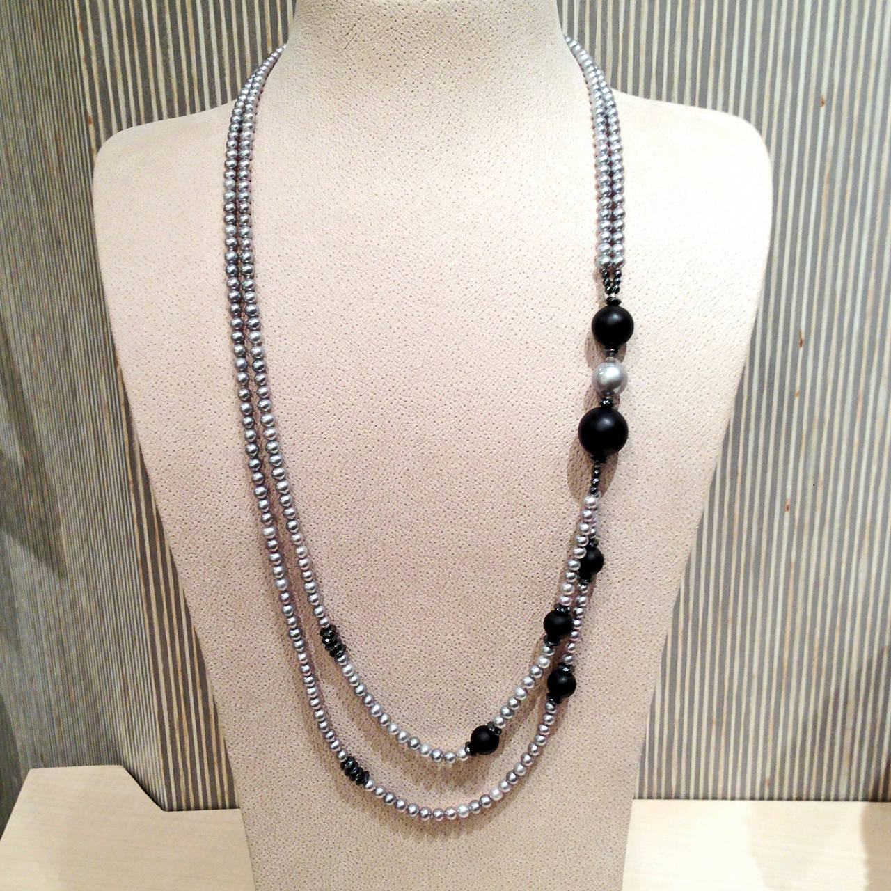 Necklace handstrung with silver pearls, onyx spheres, and black spinel accents and an ornamental clasp.