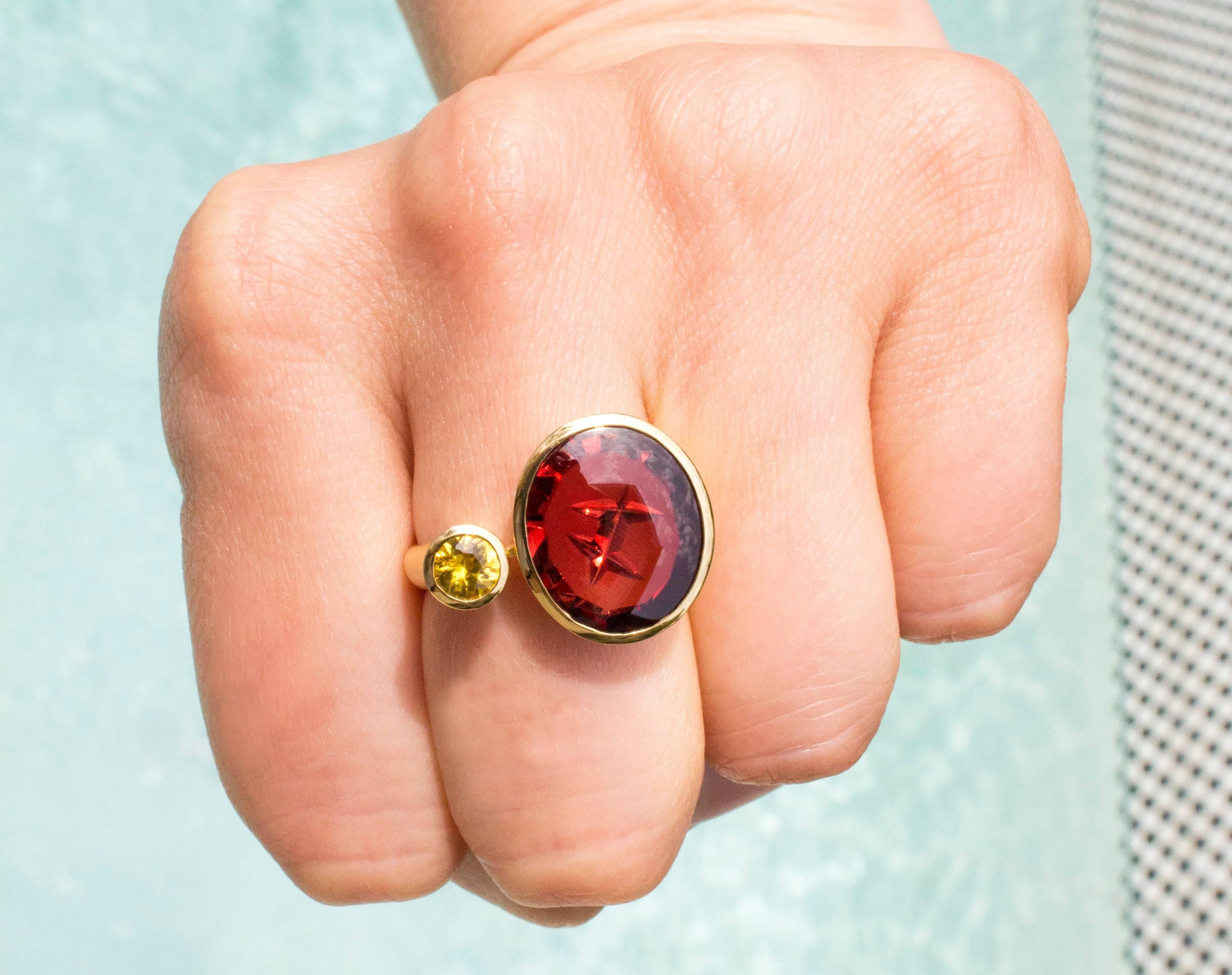 One-of-a-Kind Ring handcrafted in Germany in satin-finished 18k yellow gold by world-renowned Atelier Munsteiner in Germany, featuring a spectacular 6.41 carat custom-cut spessartine garnet and 0.43 carat shimmering yellow sapphire (0.43tcw). Size