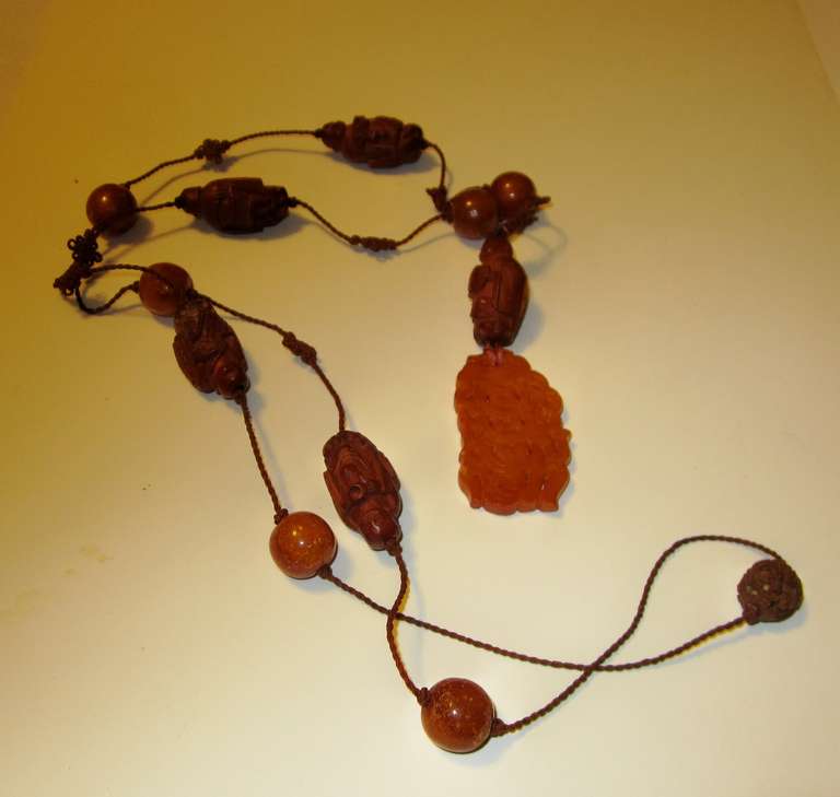 This is an antique Chinese amber and Heidao (carved nut) beaded necklace probably dating to the late 19th century-early 20th century,  with intricate Chinese knotting.  The necklace is in extremely good condition with the exception being that one