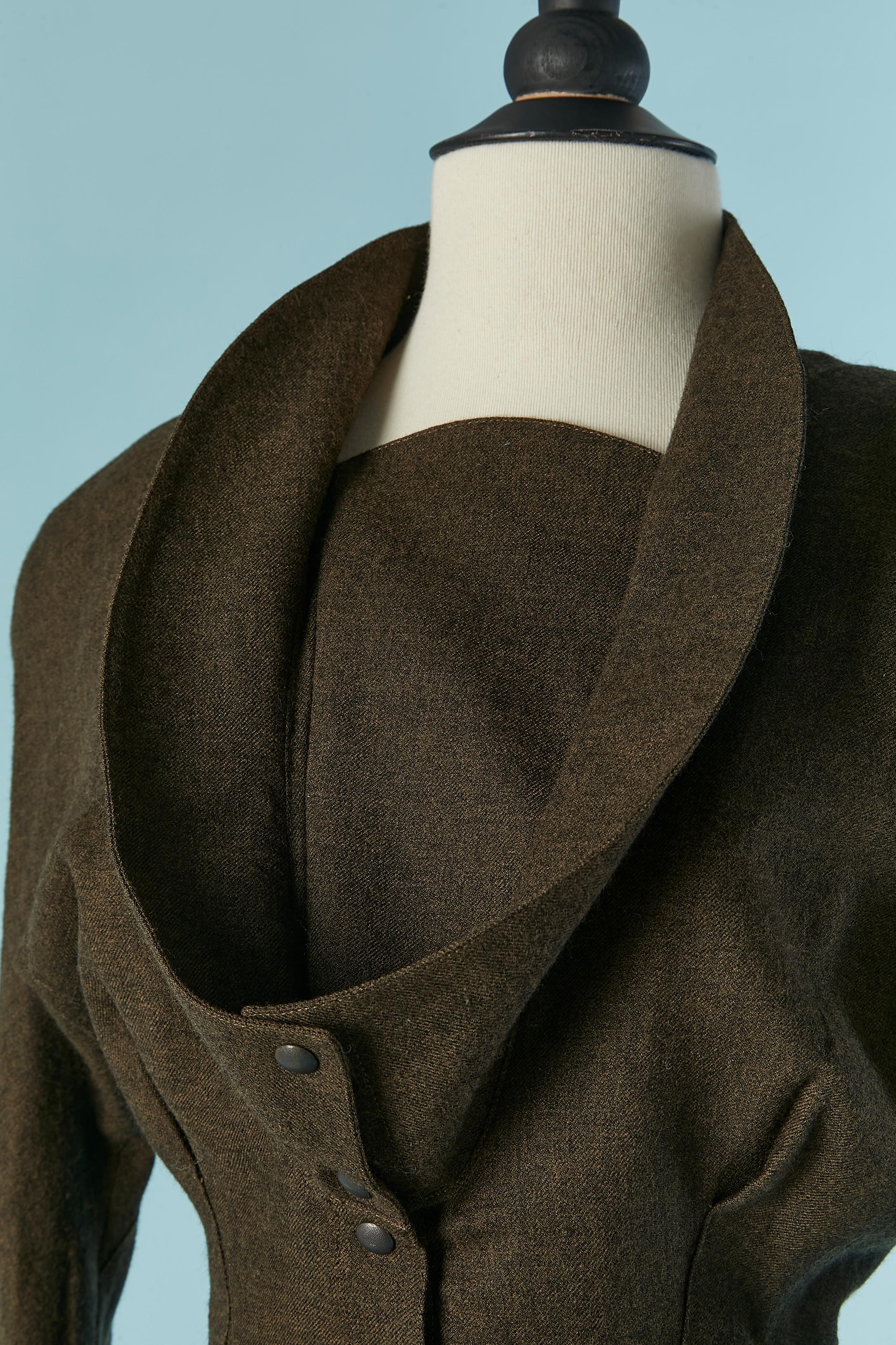 Robe en laine vert kaki. Fermeture à boutons-pression sur le milieu du devant et sous le col (sur la poitrine). Pad d'épaule. Pochette sur les deux côtés. Plis creux au dos ;
TAILLE 38 (Fr) M