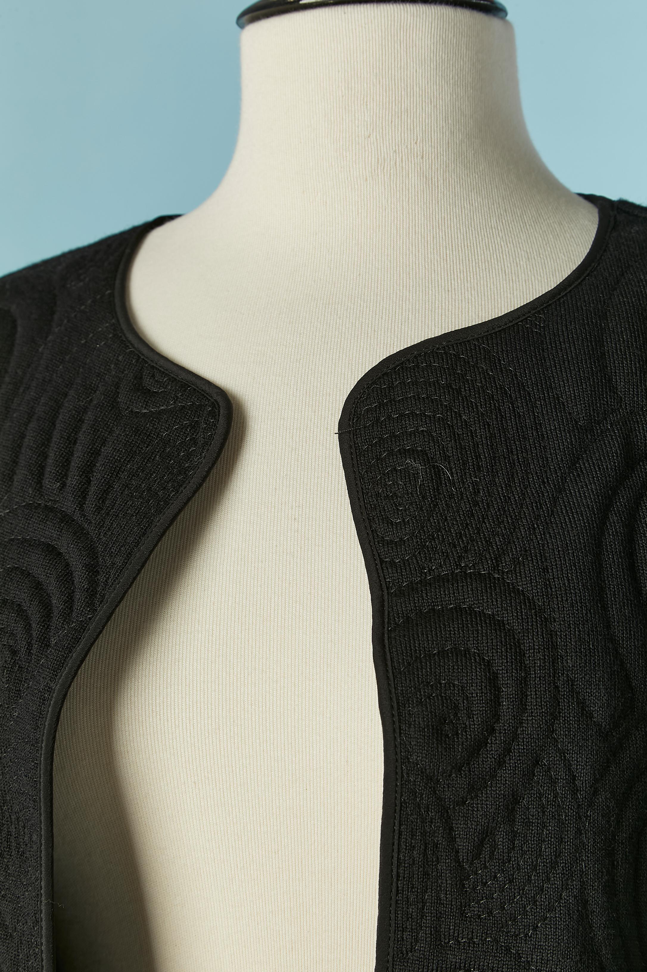 Conjunto de abrigo y falda de lana negra pespunteada. Composición del forro: 65% acetato, 35% seda.  No hay cierre en el abrigo. Bolsillo en ambos lados 
TALLA DEL CAPAZO en la etiqueta : 8 (US) 40 (Fr) L 
TALLA DE LA FALDA en la etiqueta : 10 (US)