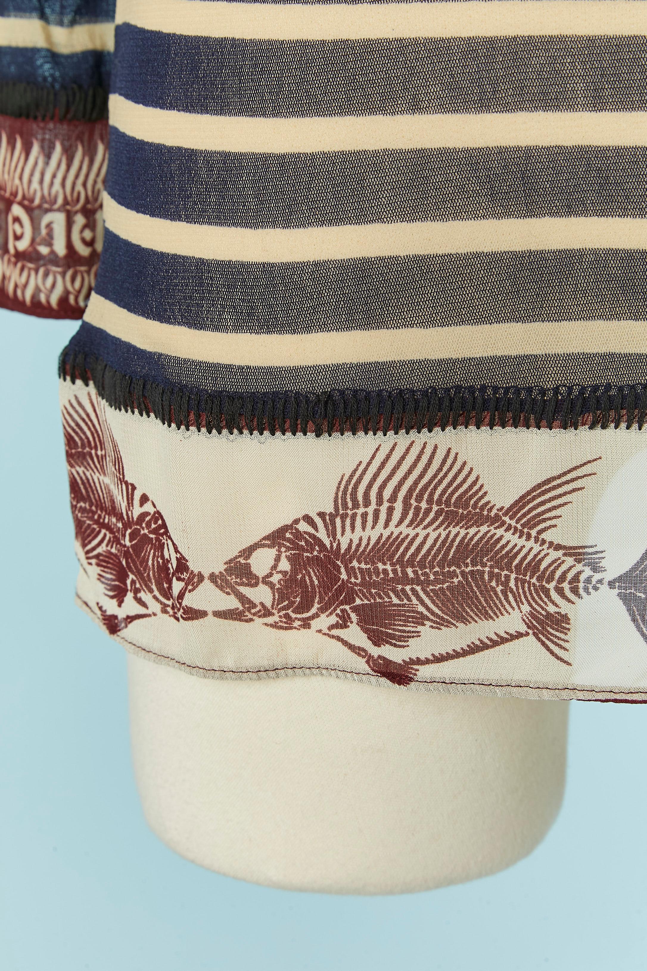 Tul elástico transparente con estampado de rayas y peces . Un botón y ojal en la parte superior del hombro. 
TALLA M 
