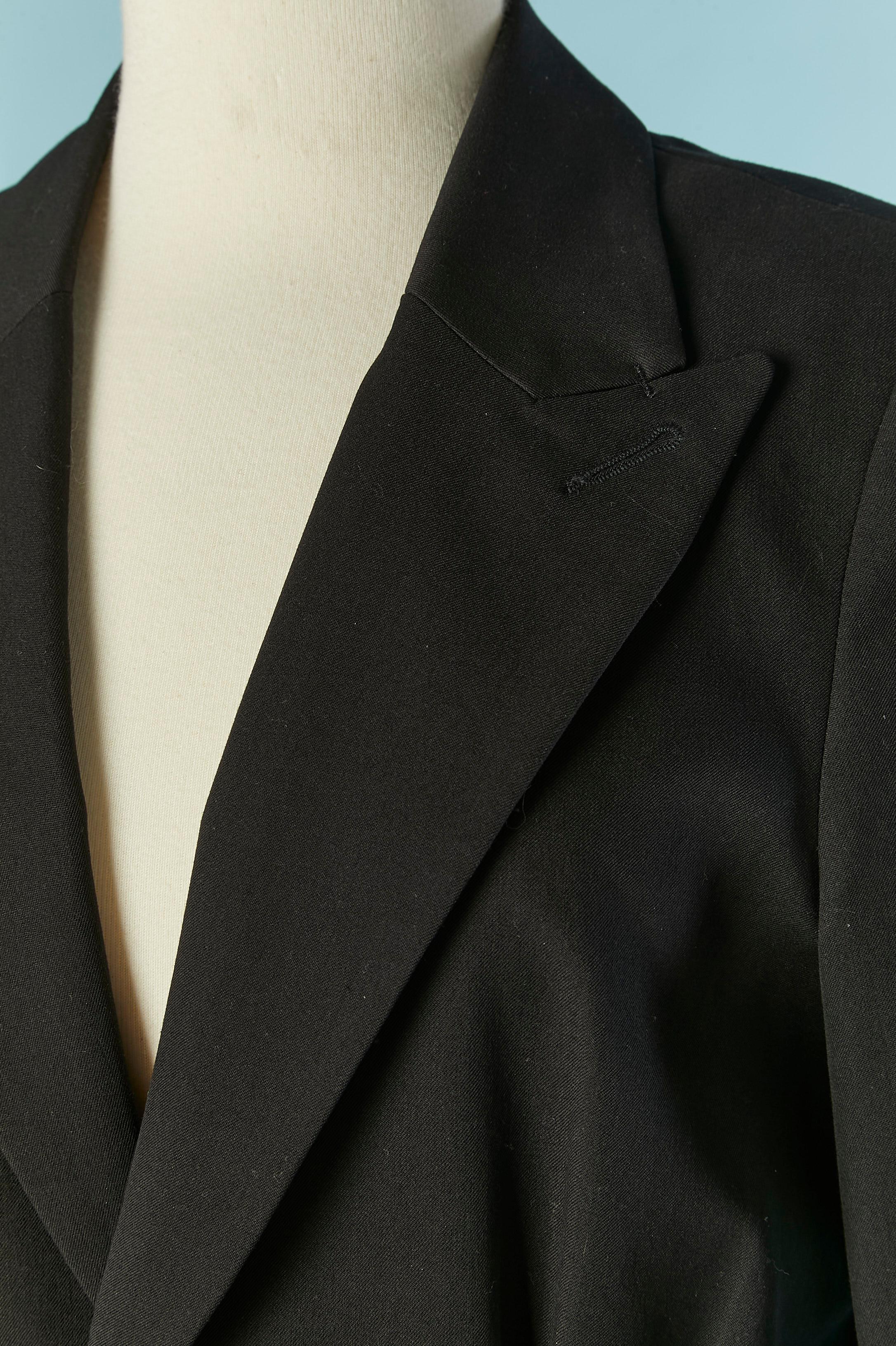 Giacca nera monopetto con zip in vita.  Composizione del tessuto principale: 77% poliestere, 21% rayon, 2% elastan. Fodera: 100% poliestere (stampa con zip) Pad. Chiusura con bottoni e asole sul centro davanti e sui polsini. Sono previsti 2 bottoni