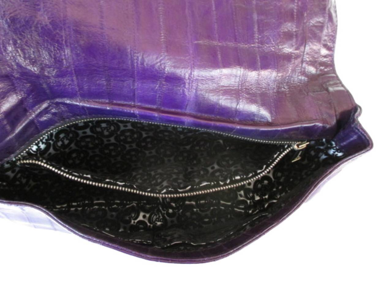 Phillip Plein is a German born designer who makes very exclusive fashion.
This special clutch is made from softes purple leather with a black  bounty hunter crocodile panel.
Inside there is a pocket with a zipper and 2 other pockets, the lining is