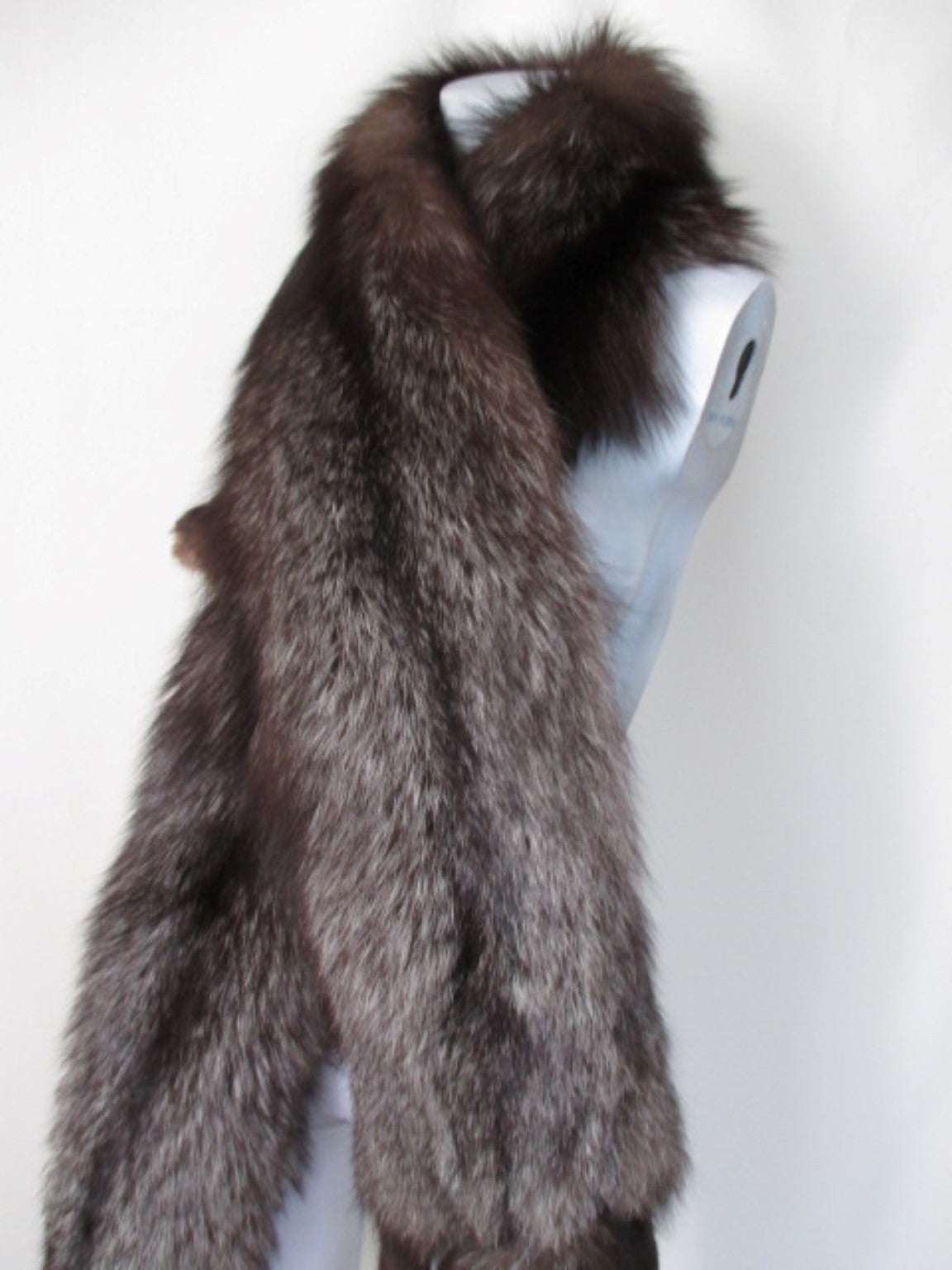 This luxurious vintage silver fox long stole shawl wrap, dates from the 20 century. It is made of fluffy plush soft supple silver gray blackish brown fox fur pelts with tip tails. 
It is 2 complete matched foxes with 8 leg paws.
You can wear it