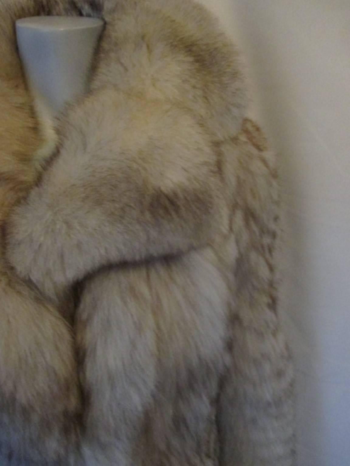 This vintage arctic fox fur coat is in very good vintage condition, it has 2 pockets and  3 closing hooks.
The back of the collar, the underside of the sleeves and at the front closing inside is finished with leather. The lining has some tear and