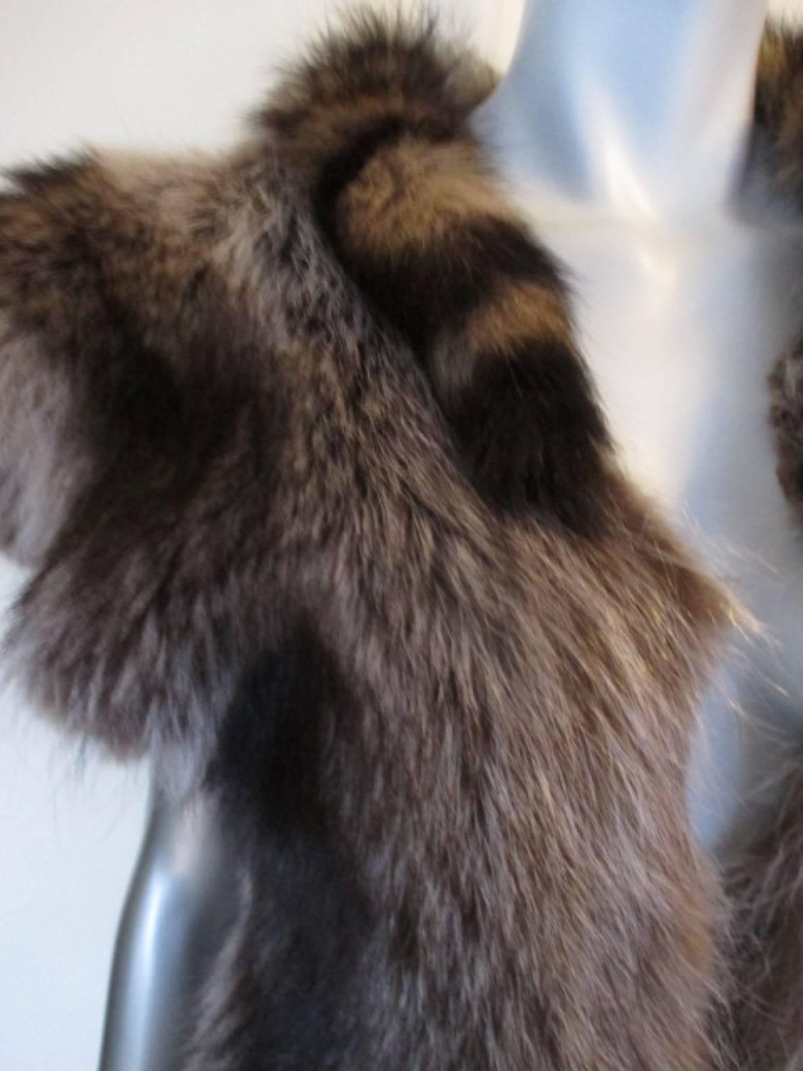 This vest is nice to wear and is made of very soft raccoon fur and has 2 little tails at the collar.
The inside is soft natural skin and unlined , no pockets.
Size fits like eu 38