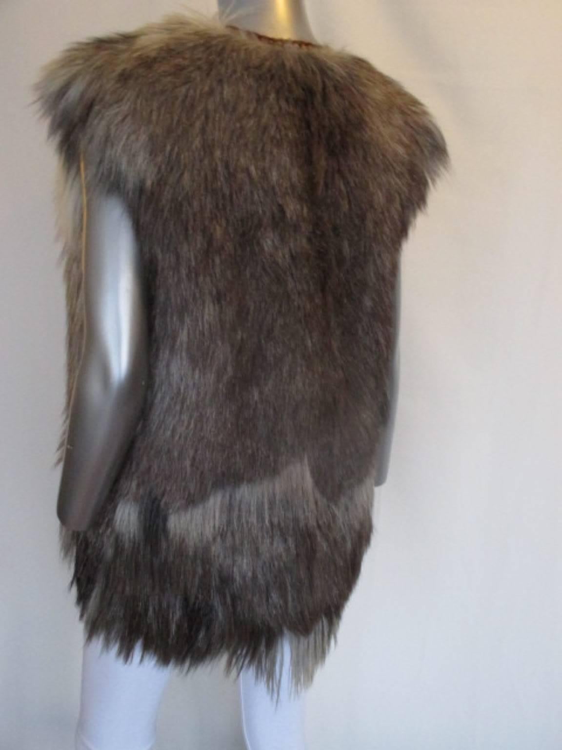 The vest is fully lined with black satin. The neck and front edges of the vest are trimmed in cord. The cord is woven and has  orange, burgundy and black fibers. 
At bust level, at the front of the vest, there are two large brown buttons and one