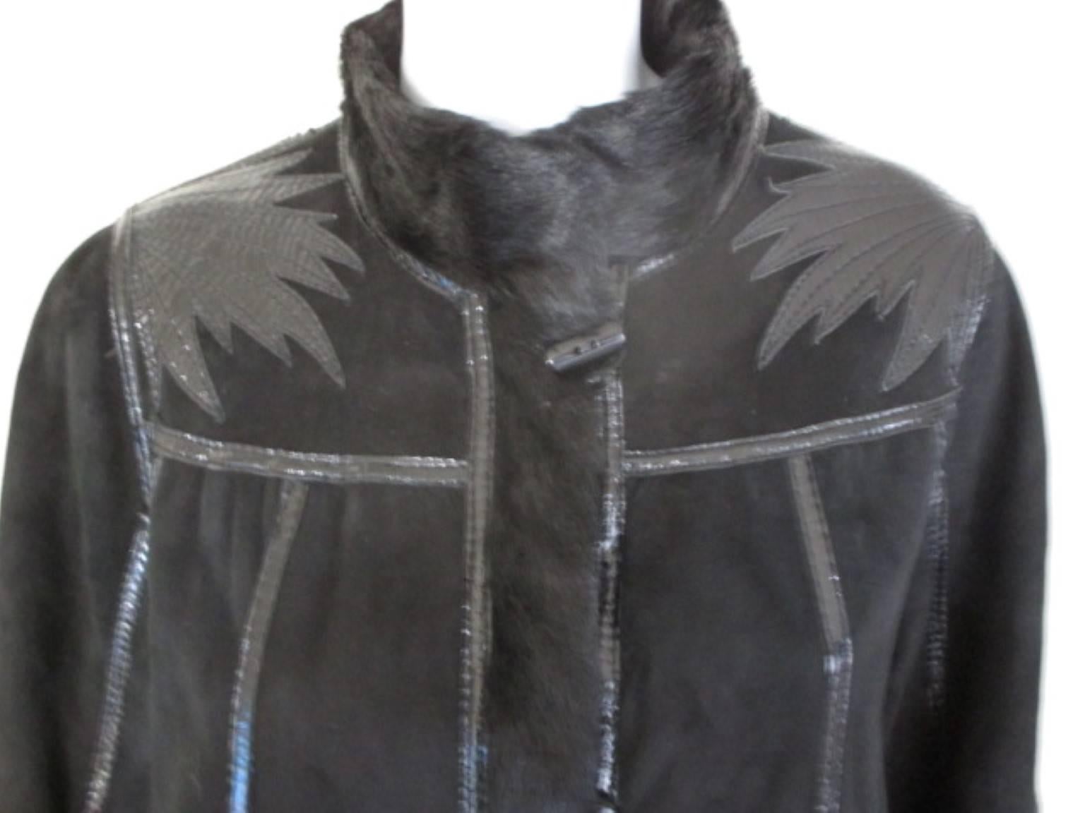 This vintage coat is with 2 pockets, 4 closing buttons and is reversible.

We offer more fur items, view our frontstore

Details;
Trimmed with patent leather and apliques on shoulders.
Color.; black
One side suede keather and one side lamb skin 
Its