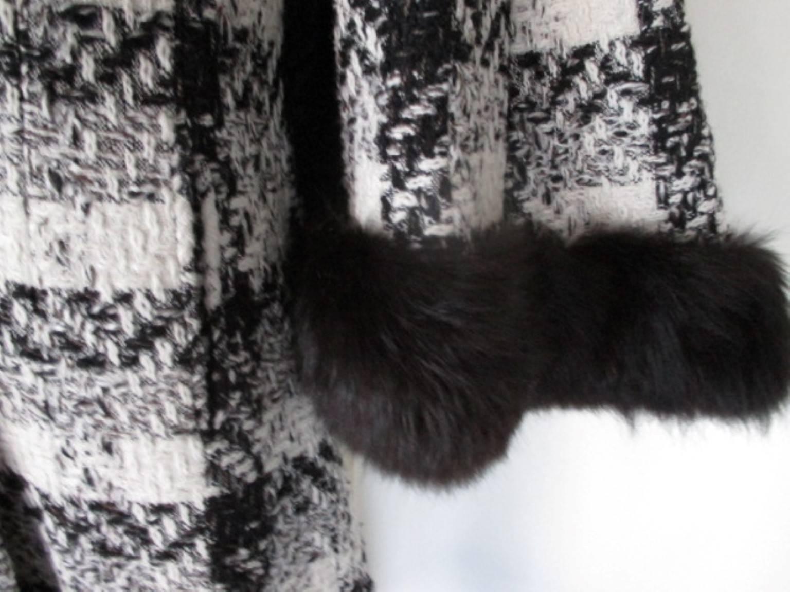 Offriamo altri articoli vintage esclusivi, guarda il nostro frontespizio.

Questo cappotto in lana bianco e nero ha una mantella attaccata con 2 tasche, 3 bottoni e rifinita con pelliccia di volpe nera.
È in ottime condizioni.
Sembra essere piccolo,