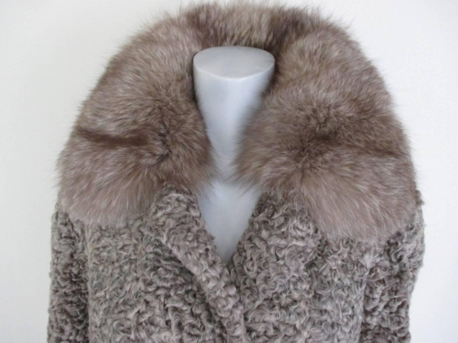 Amazing persian lamb fur coat with fox fur collar and cuffs. 
With 2 pockets, 1 closing hook, 1 inside closing button and a snake leather belt.
Labeled: Christian Dior Boutique Fourrure.

Fur is in excellent and clean vintage condition.
Size is