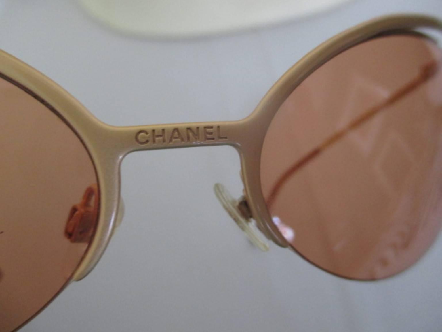 These super-stylized matte gold frame sunglasses have rimless oval orange color lenses and is very light to wear.
CC gold metal logos on the bottom of the arms, Chanel engraved on the nose bridge and lenses
Its in excellent vintage condition with a