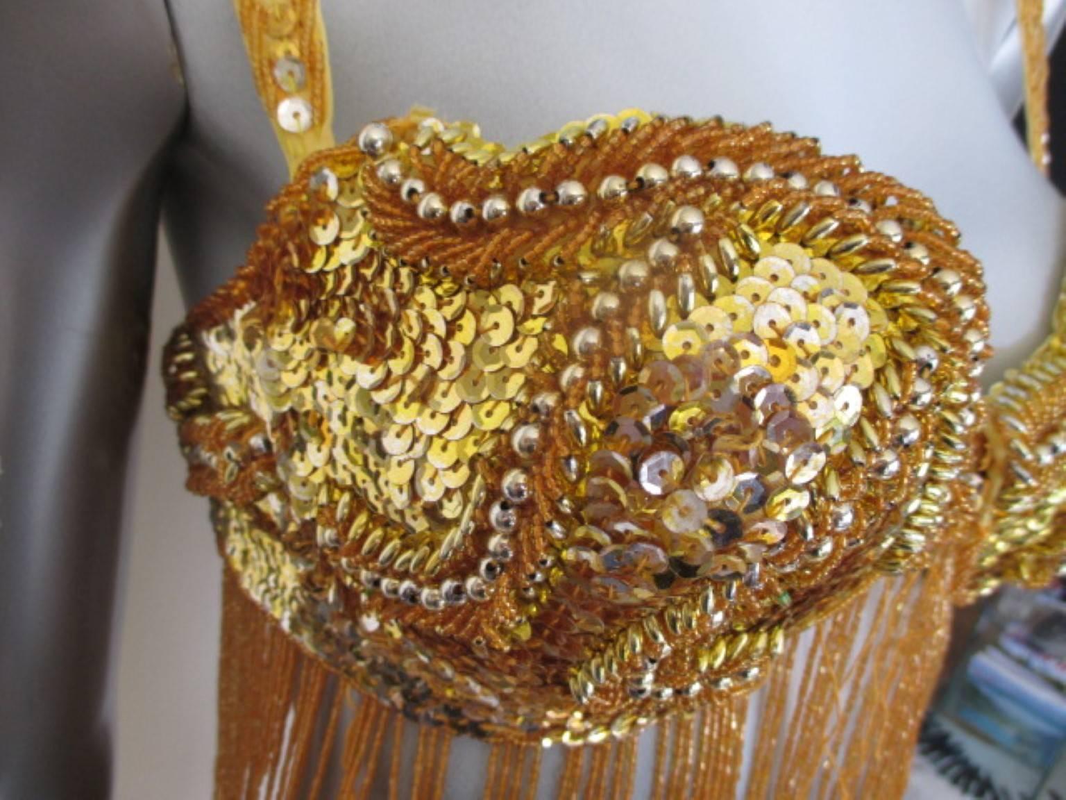 This bra is made from gold color sequins and fringe,
Its in good condition with minimum wear of use.
Size 80 cm/ 31.49 inch

Please note that vintage items are not new and therefore might have minor imperfections.