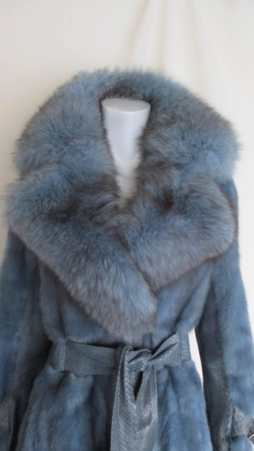 This vintage fur coat is made from soft dyed blue mink and  python details with a dyed fox fur collar.
The coat has 2 pockets a belt which is attached to the coat and 3 closing hooks.
Its in very good vintage condition with minimum wear at the edge