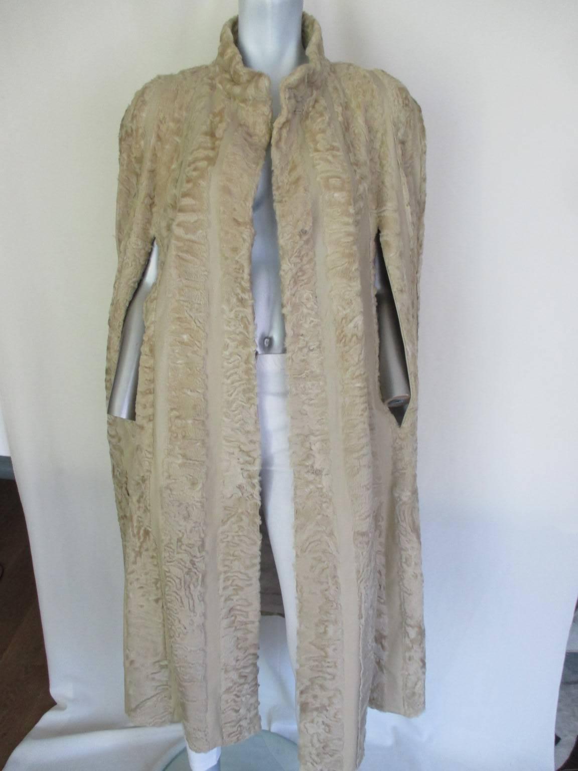 This rare Art deco style vintage Persian Lamb cape with leather details/panels, with 3 closing buttons and one at the collar.
2 pockets are made in the silk lining.
Its in good vintage condition 
Size fits small to medium

Please note that vintage