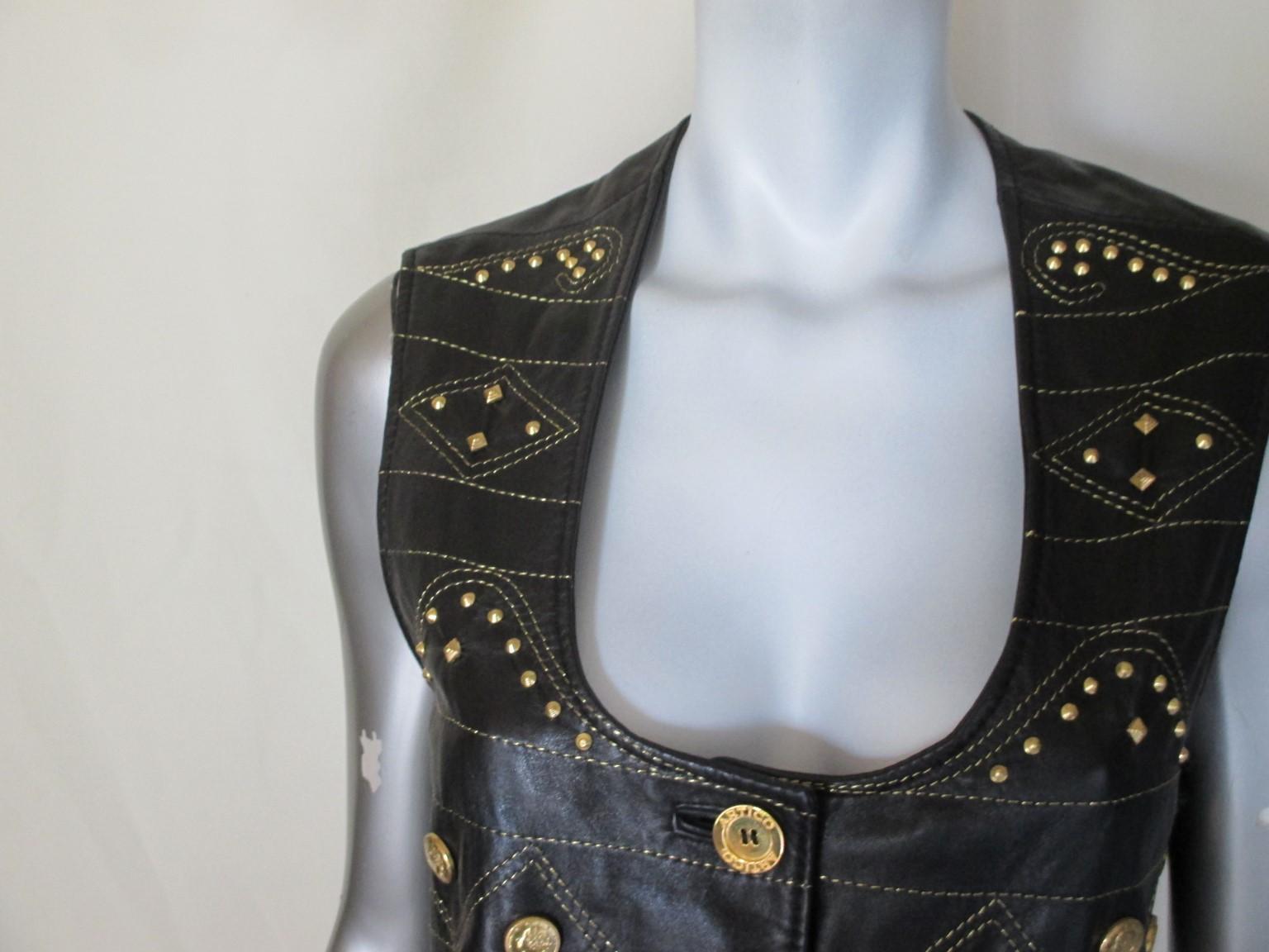 This black leather vest has no pockets, trimmed with gold toned studs and 5 gold color buttons.
Its designed by Artico, Bologna, Italy
Versace style
Size is Italian 44/ US 8-10/EU 40
Please note that vintage items are not new and therefore might