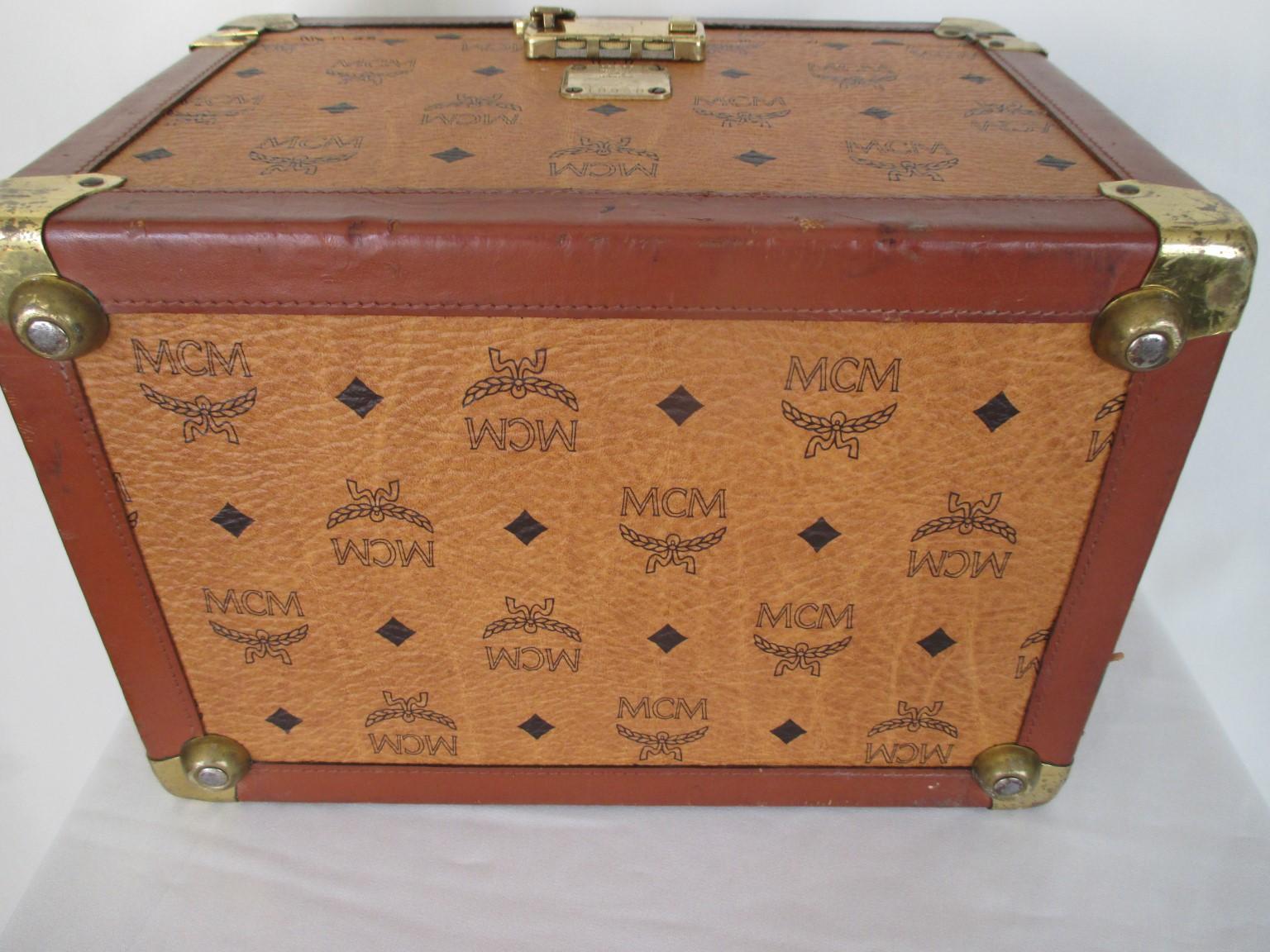 MCM authentic Vintage cosmetic traveling case in the Mode Creation Munich (MCM) signature cognac color pattern. 
Inside with mirror 
Number at front is 18938
Pre loved condition with overall wear
sizes 31,5 cm x 21,5 cm x 23 cm
Inches: 12.40 x 8.46