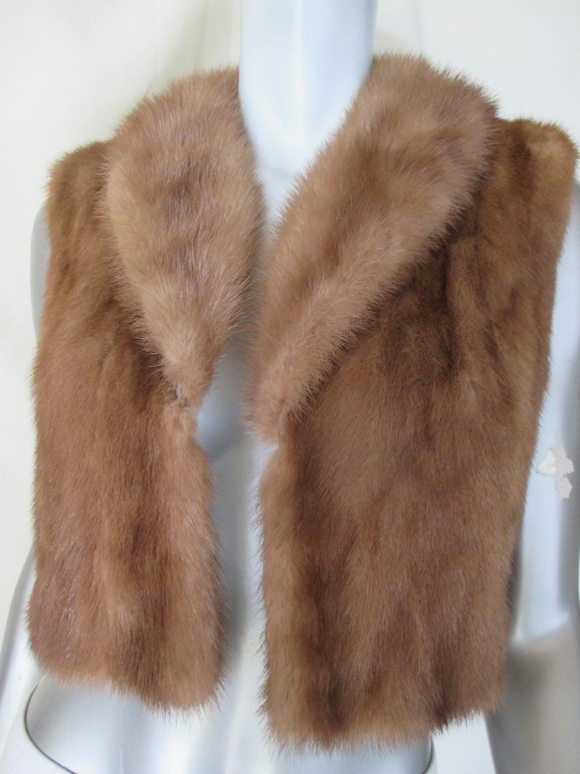 This vintage mink fur jacket is made of brown mink with leather side panels and can be worn sleeveless or with the knitted sleeves with closing buttons.
It has no pockets and 1 closing hook
From Scarbroughs, Austin, designer collection
in good