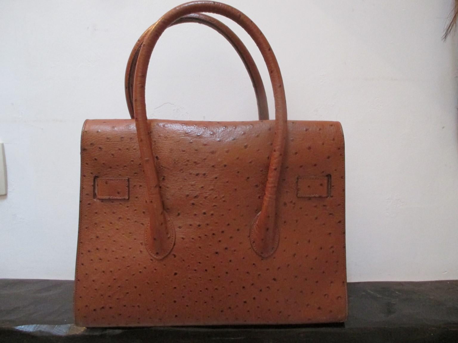Brown/cognac embossed ostrich leather bag with gold hardware.
Lining is leather with 1 zipper pocket
good vintage condition with some wear.
size; 24.5cm  x 31.5cm  x 12 cm
Please note that vintage items are not new and therefore might have minor