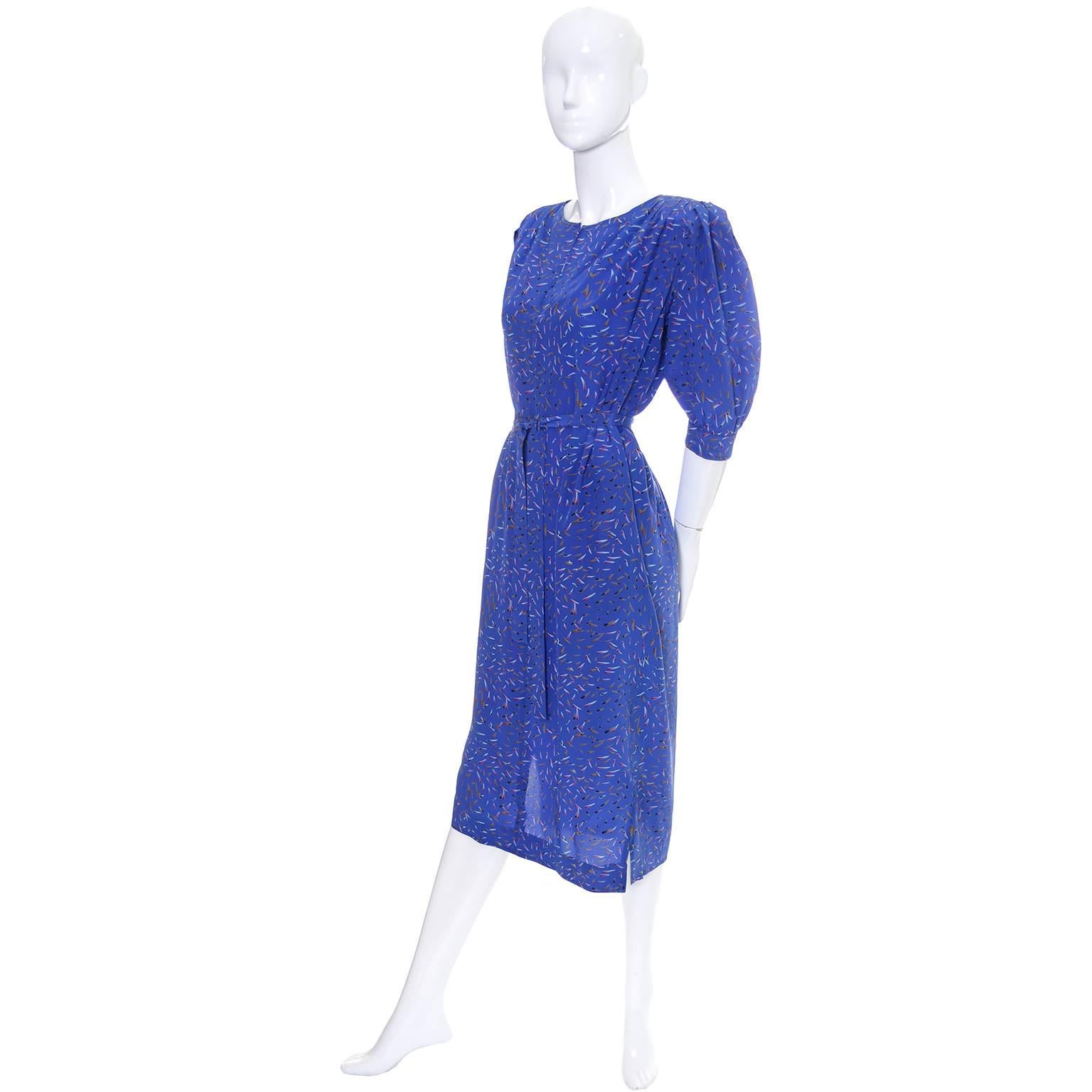 This pretty blue abstract print silk vintage Ungaro Parallele dress comes with a fabric sash and is in excellent condition. The dress has gathers at the shoulders, side slit pockets, shoulder pads, and 3/4 length gathered sleeves.  The dress is