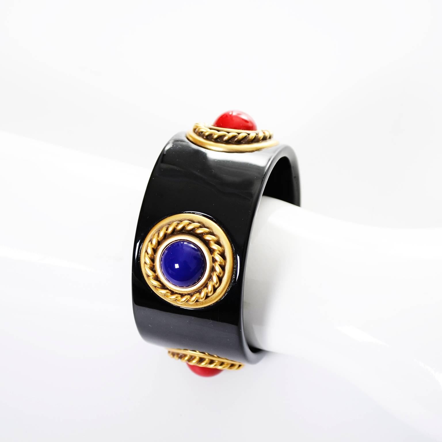 This is an incredible 1980s vintage bangle bracelet from YSL in black enamel with Multi colored cabochons set in braided gold plate metal.  This bracelet is 1 and 1/4 inch wide and measures 7 and 1/2 inches in circumference on the inside.  This