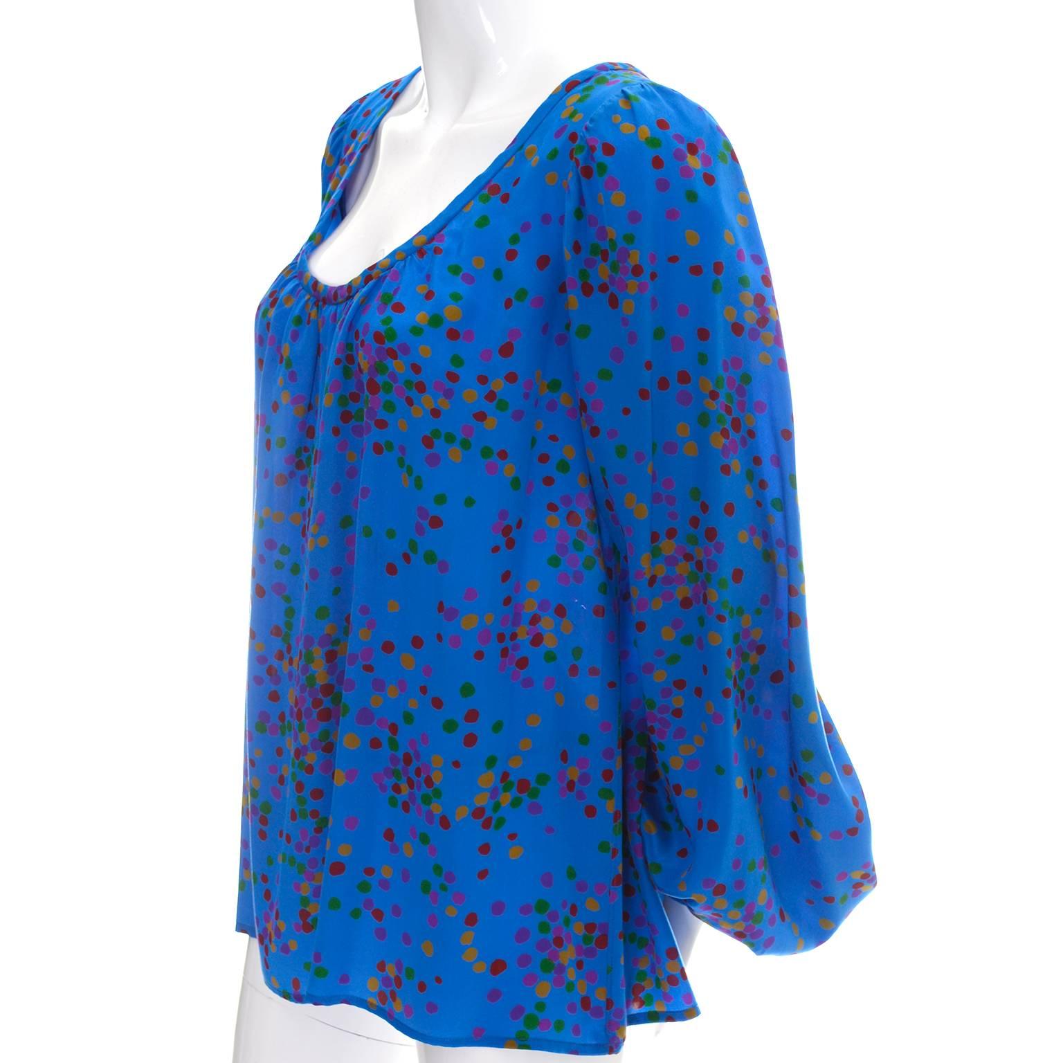 This beautiful YSL Rive Gauche vintage blue silk blouse has multi colored polka dots and bishop sleeves. This piece was designed in the late 1970's by Yves Saint Laurent and is a peasant style top, meant to be worn loosely fitted.  This top is in