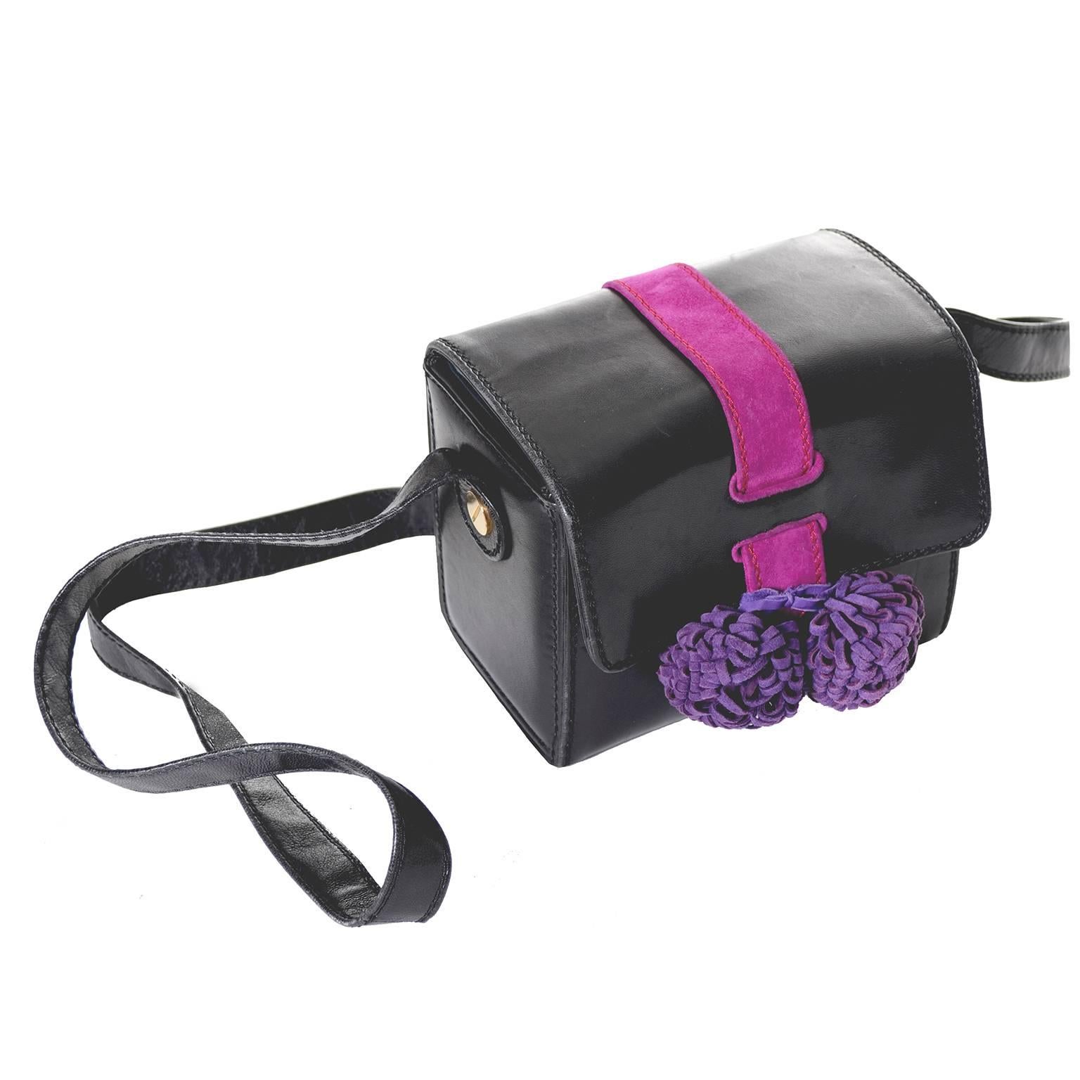 This is a rare style vintage handbag from designer Maud Frizon.  The bag has shoulder straps and is made of black leather with fuchsia suede trim and fab purple pom poms. This 1980s Maud Frizon Handbag is from an estate I recently acquired that