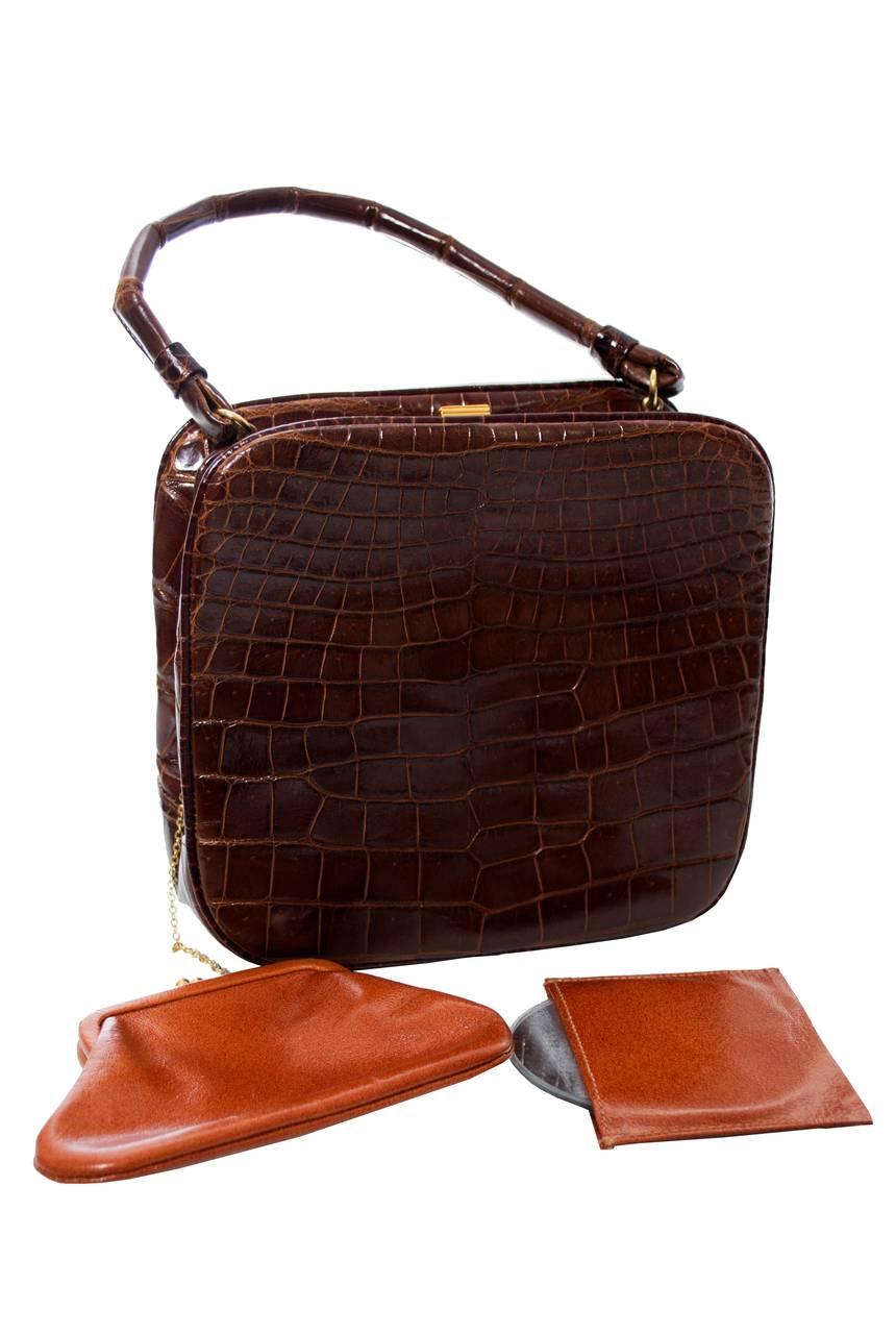 You'll love this beautiful 1950's genuine alligator Koret vintage handbag with original coin purse and mirror. This bag closes at the top with a gold clasp and has a 12” handle.  There are 2 inside pockets and the handbag measure 6 inches high and 6