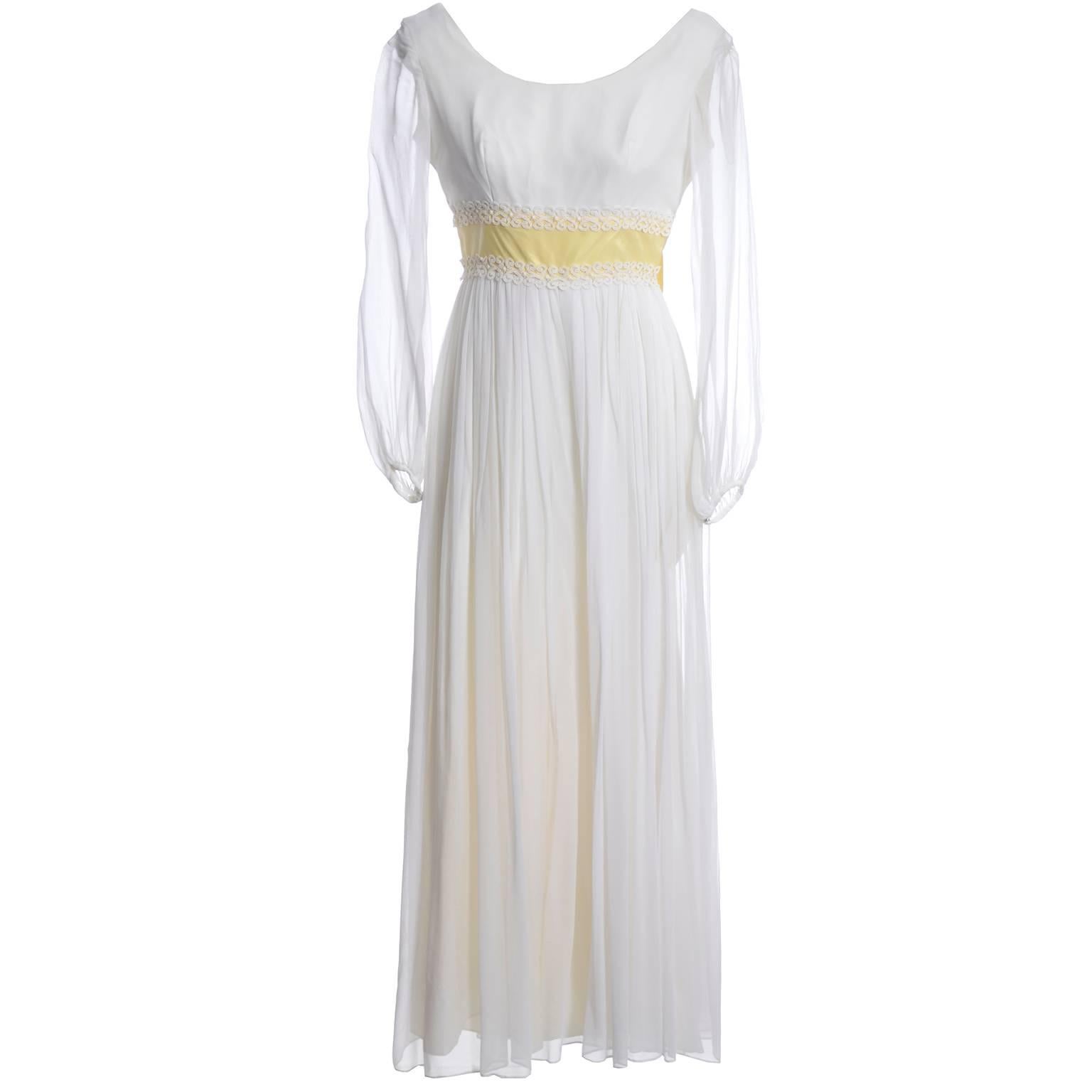 This outstanding 1960s white silk chiffon vintage dress has fantastic satin palazzo pants underneath! The dress has a yellow moire satin ribbon and back bow and is trimmed in lace. The long sleeves are sheer and the dress closes with a back metal