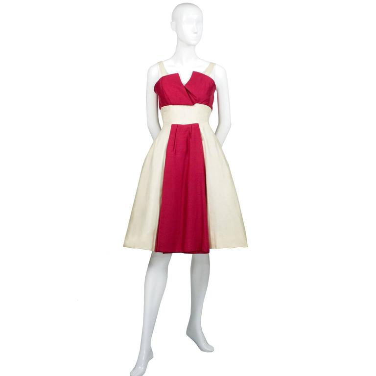 This is an exceptional red and ivory silk cocktail party dress designed by Jacques Heim and sold at Bonwit Teller in the 1950's. This beautiful dress is fully lined with a tulle skirt and closes with a back metal zipper.  The Jeunes Filles was